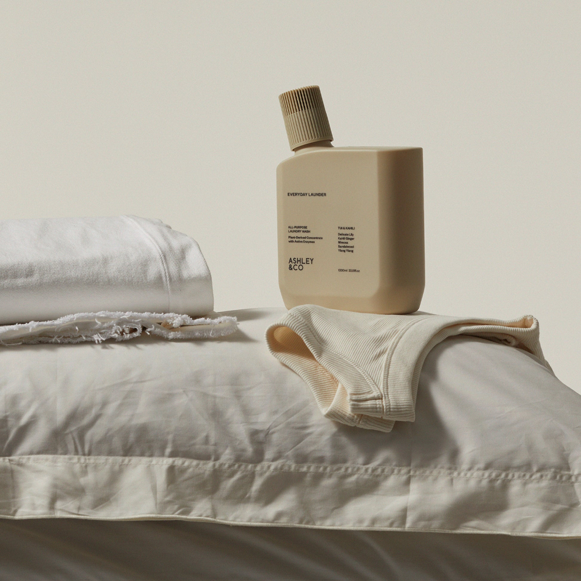 Ashley and Co 'Everyday Launder' laundry detergent bottle in Tui and Kahili fragrance on clean white freshly washed laundry.