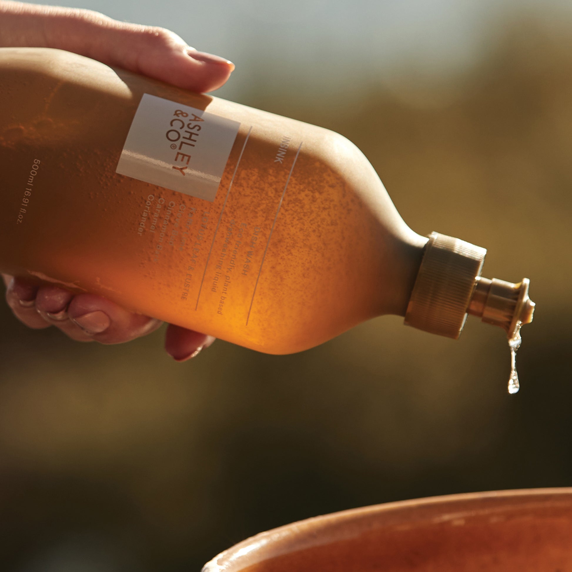 Ashley and Co 'Insink' dish wash in lotus leaf & lustre fragrance squeezing detergent into a pot.