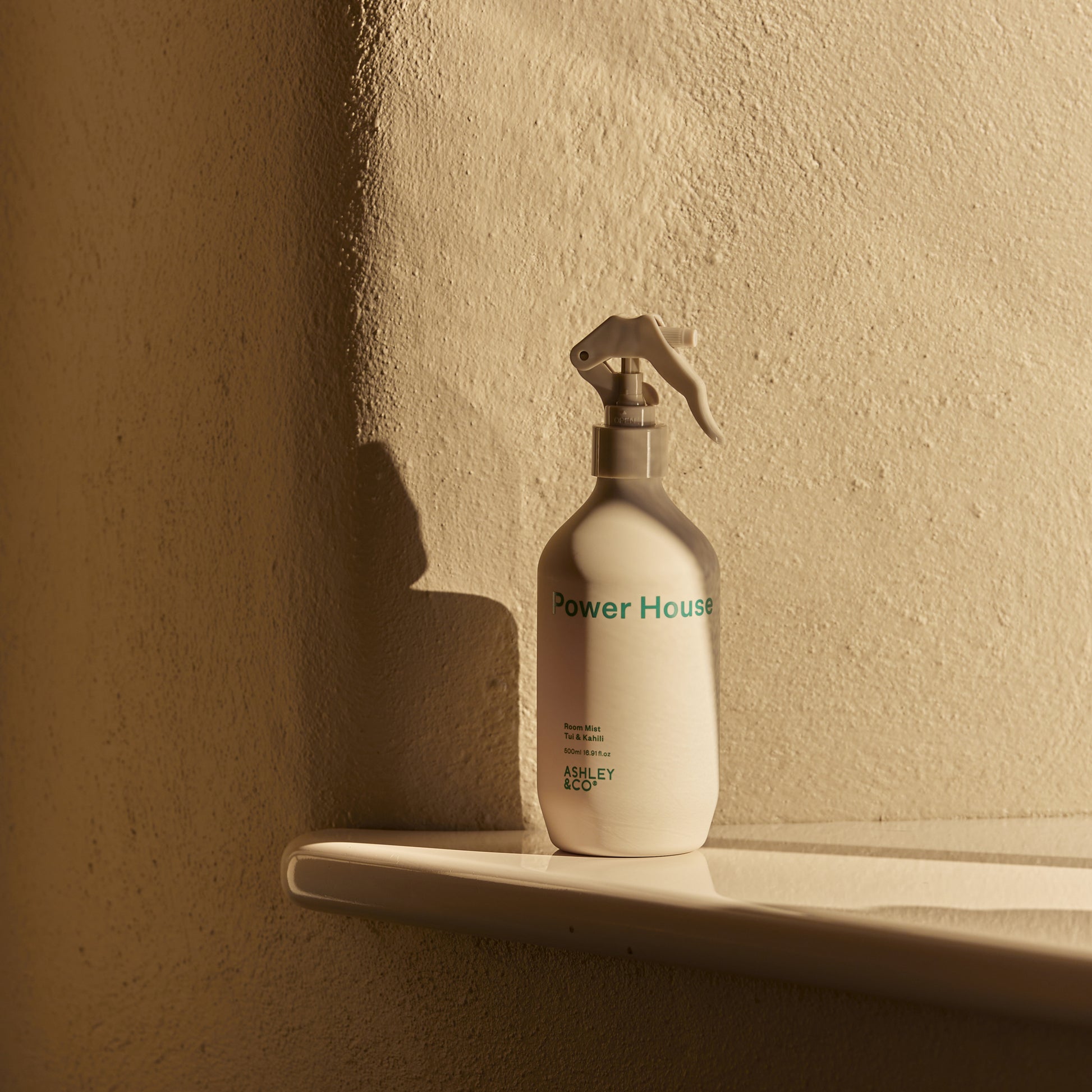 Ashley and Co 'Power House' room mist in tui and kahili fragrance placed on a bench.