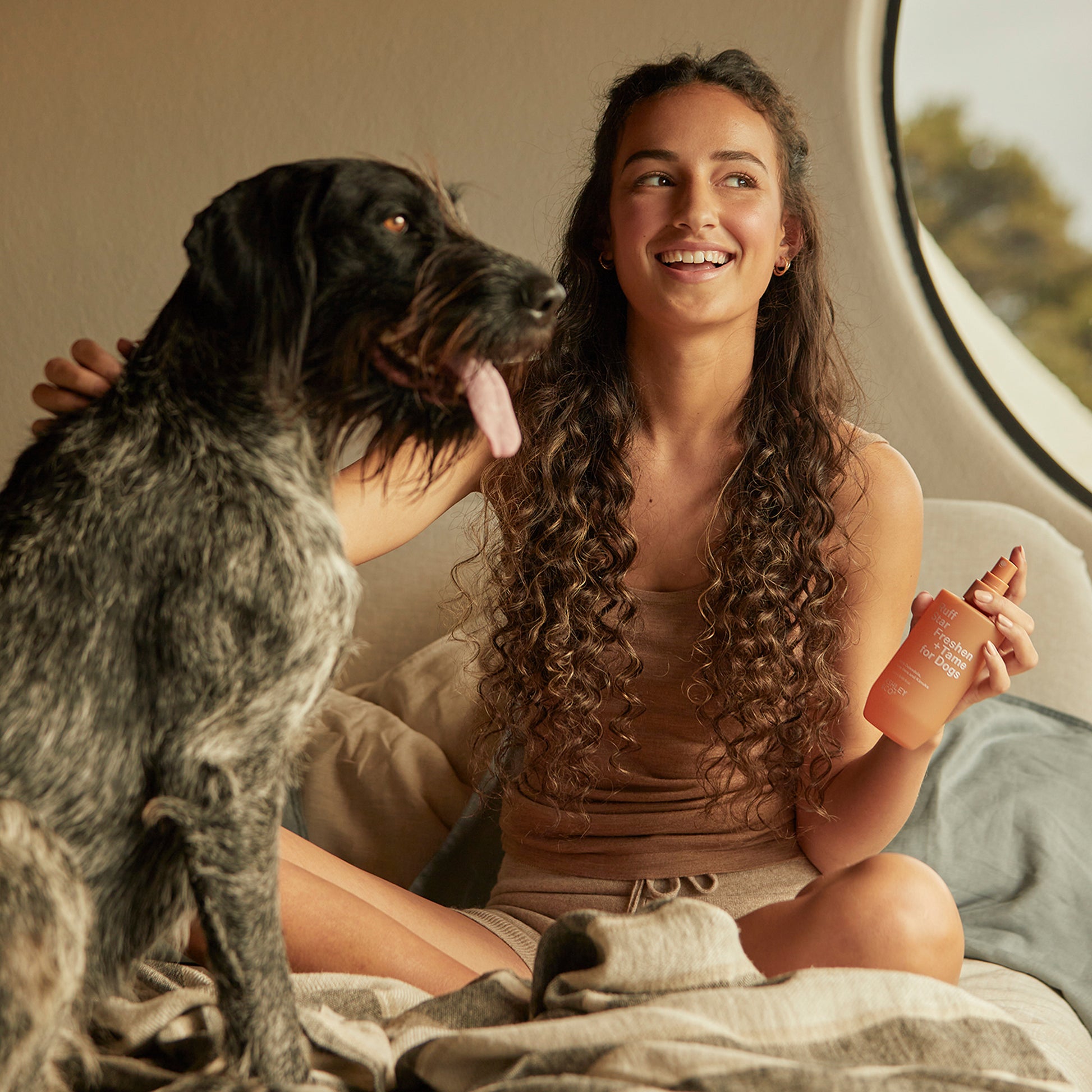 Ashley and Co 'Ruff Star' dog spray being sprayed onto a dog by a young woman.
