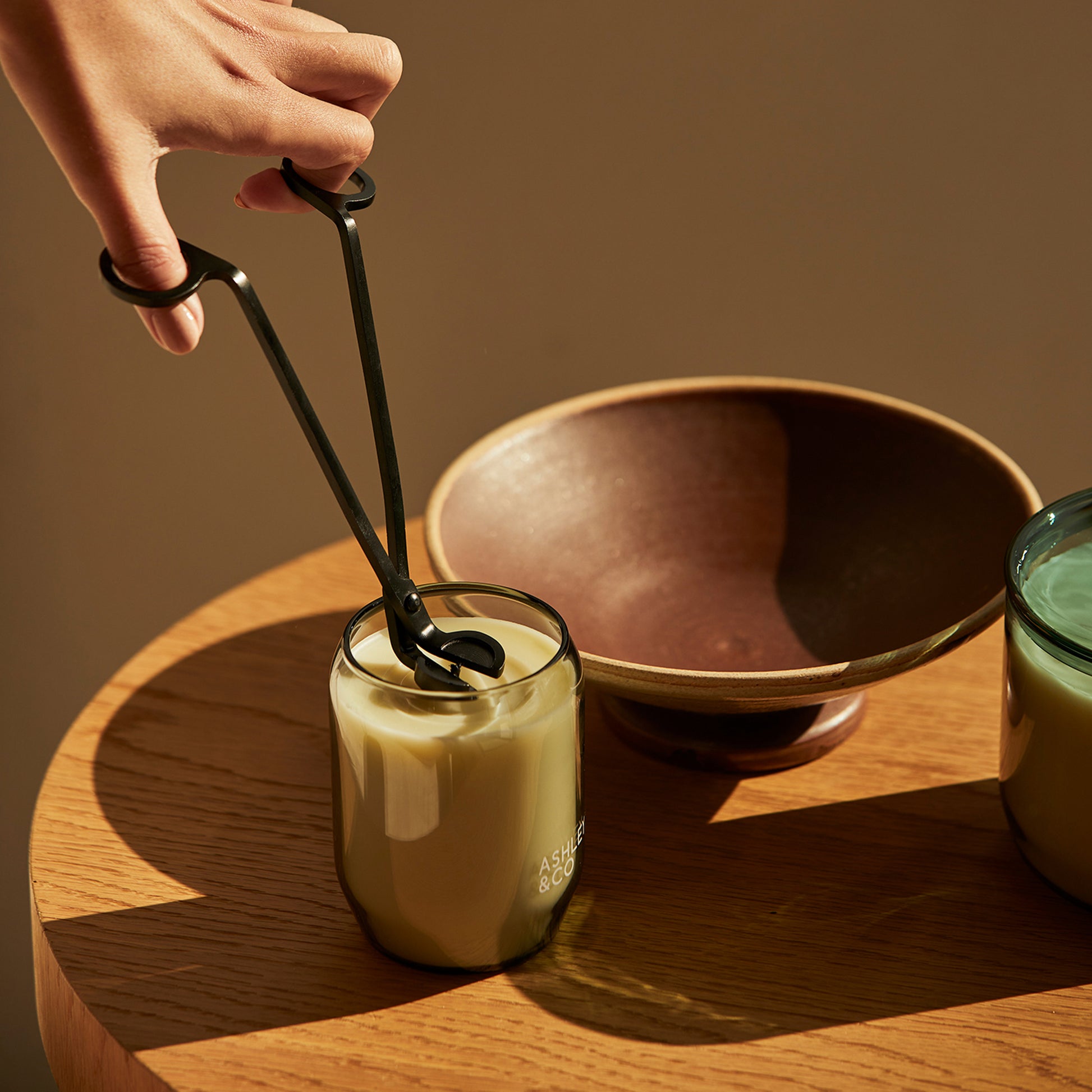 Ashley and Co "Snippy' wick trimmer scissors being used on a scented candle