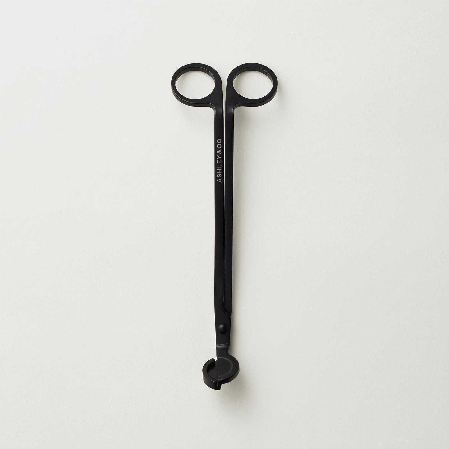 Ashley and Co "Snippy' wick trimmer scissors on a grey background.