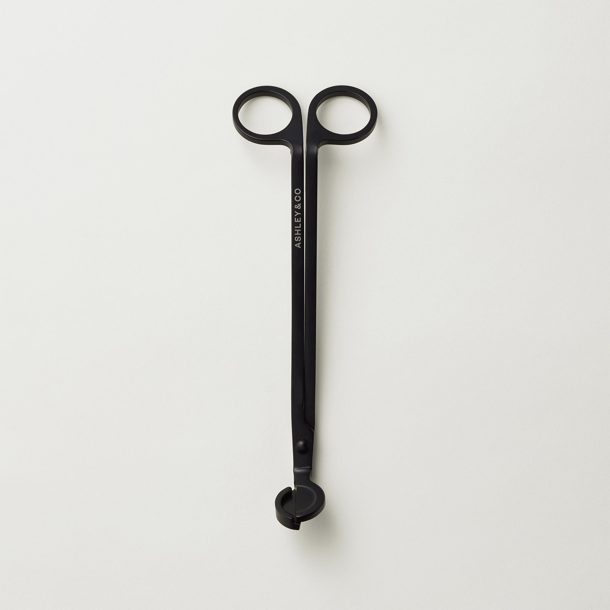 Ashley and Co "Snippy' wick trimmer scissors on a grey background.