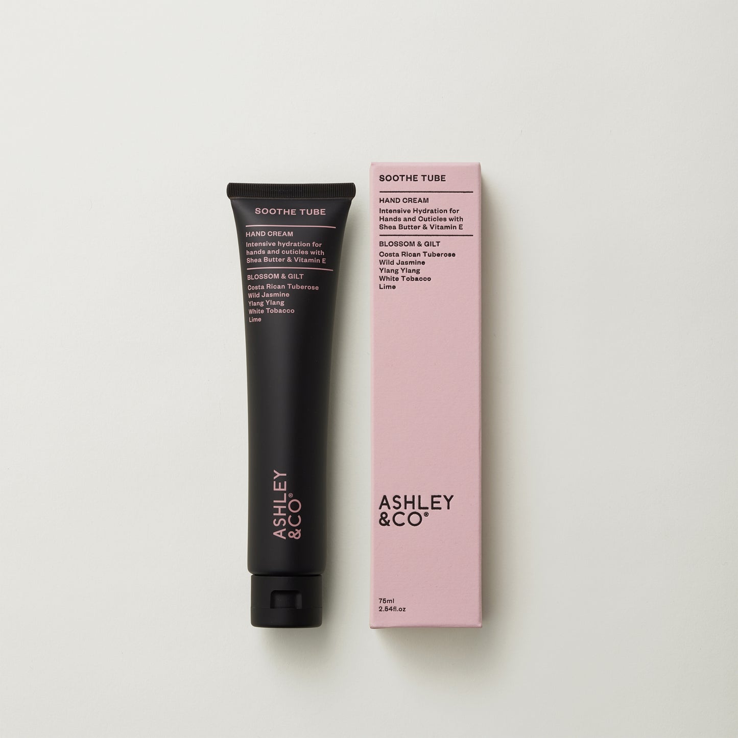 Ashley and Co 'Soothe Tube' handcream in blossom and gilt fragrance on a grey background.