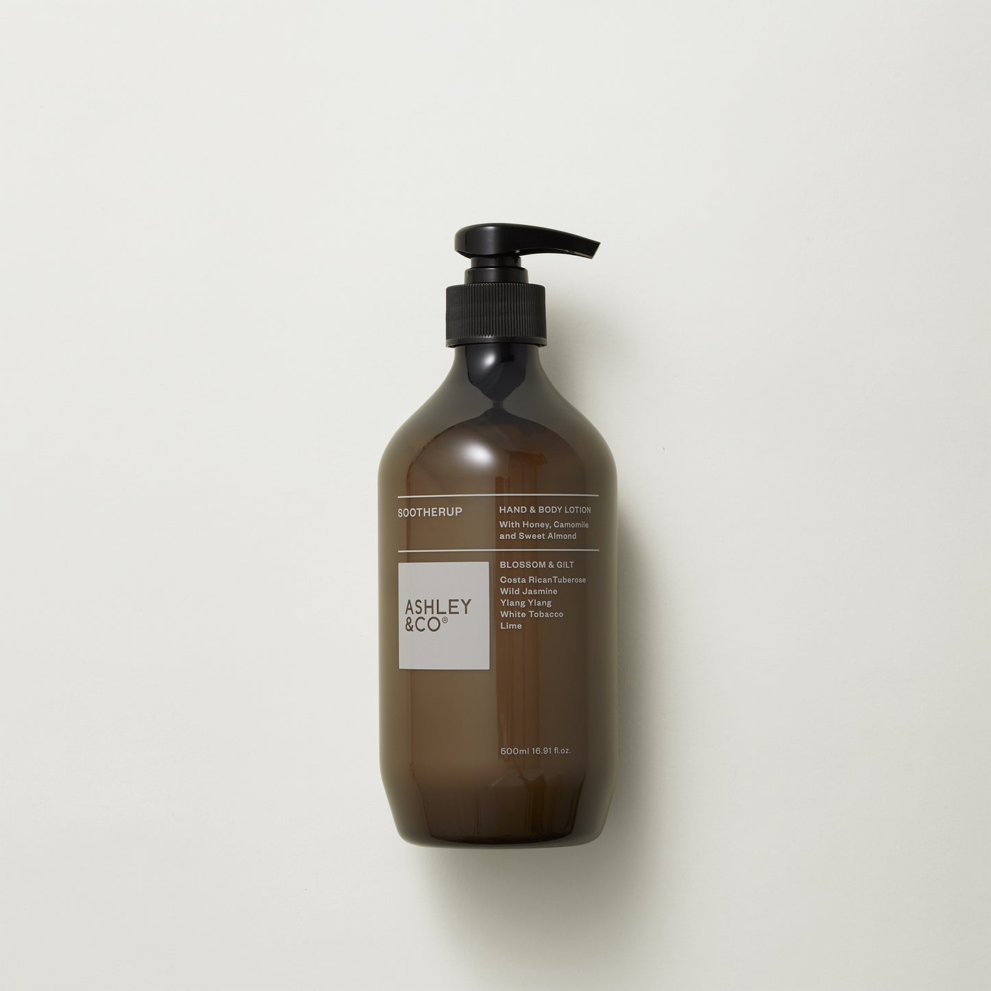 Ashley and Co 'Sootherup' hand and body lotion in blossom and gilt fragrance on a grey background.