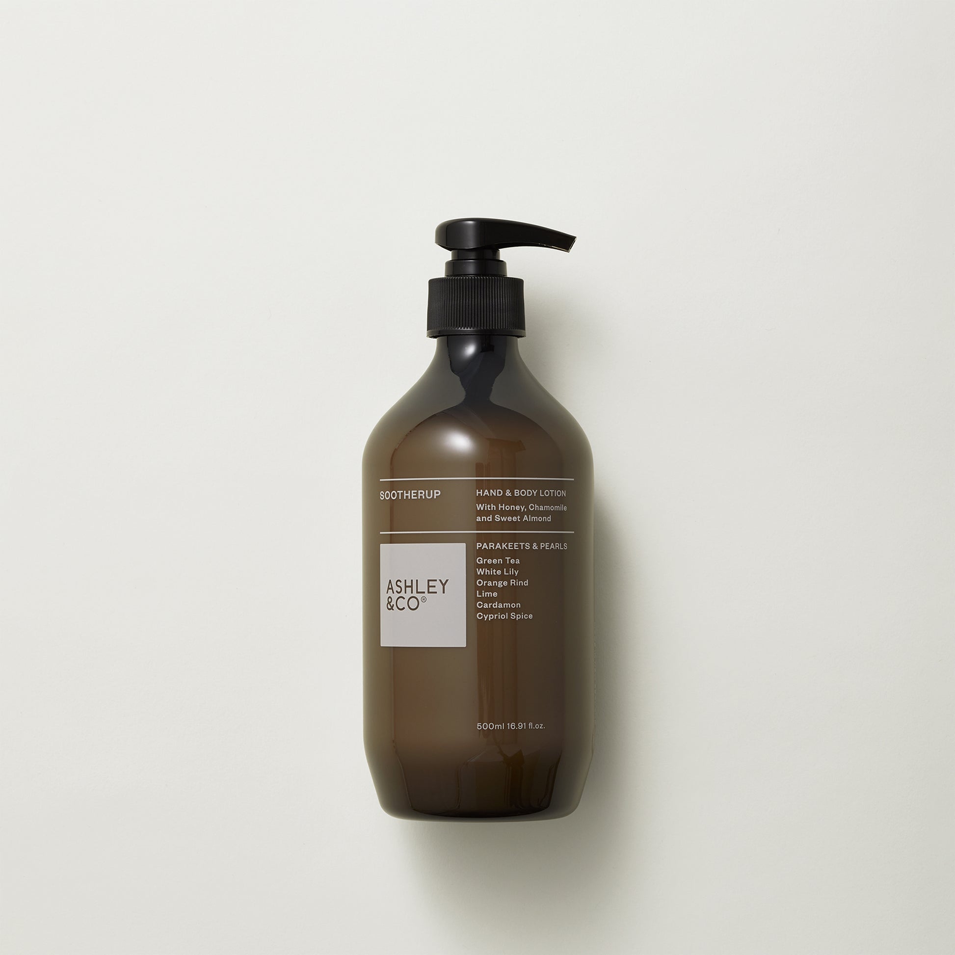 Ashley and Co 'Sootherup' hand and body lotion in parakeets and pearls fragrance on a grey background.