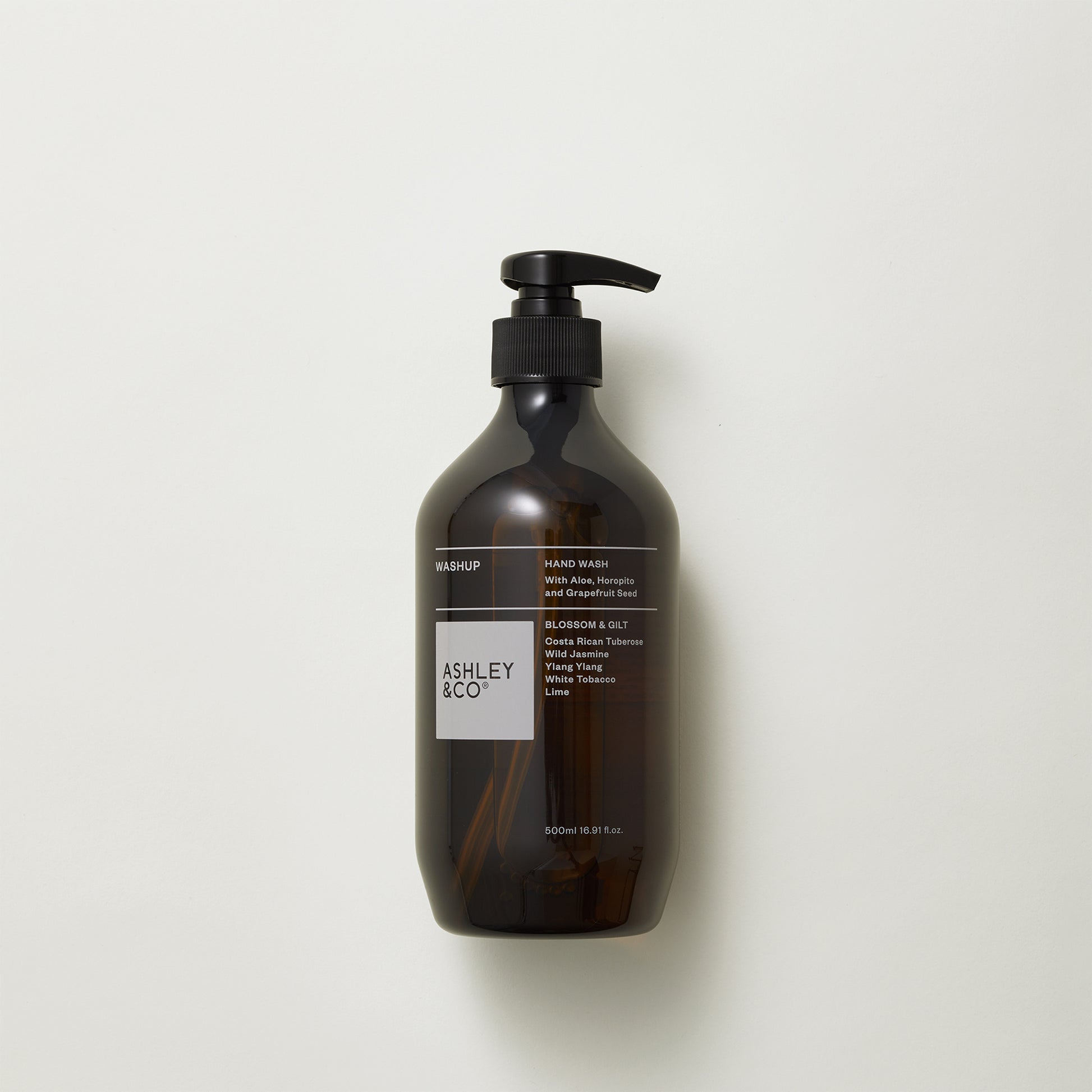 Image showing front of Ashley and Co 'Washup' handwash in blossom and gilt fragrance on grey background.