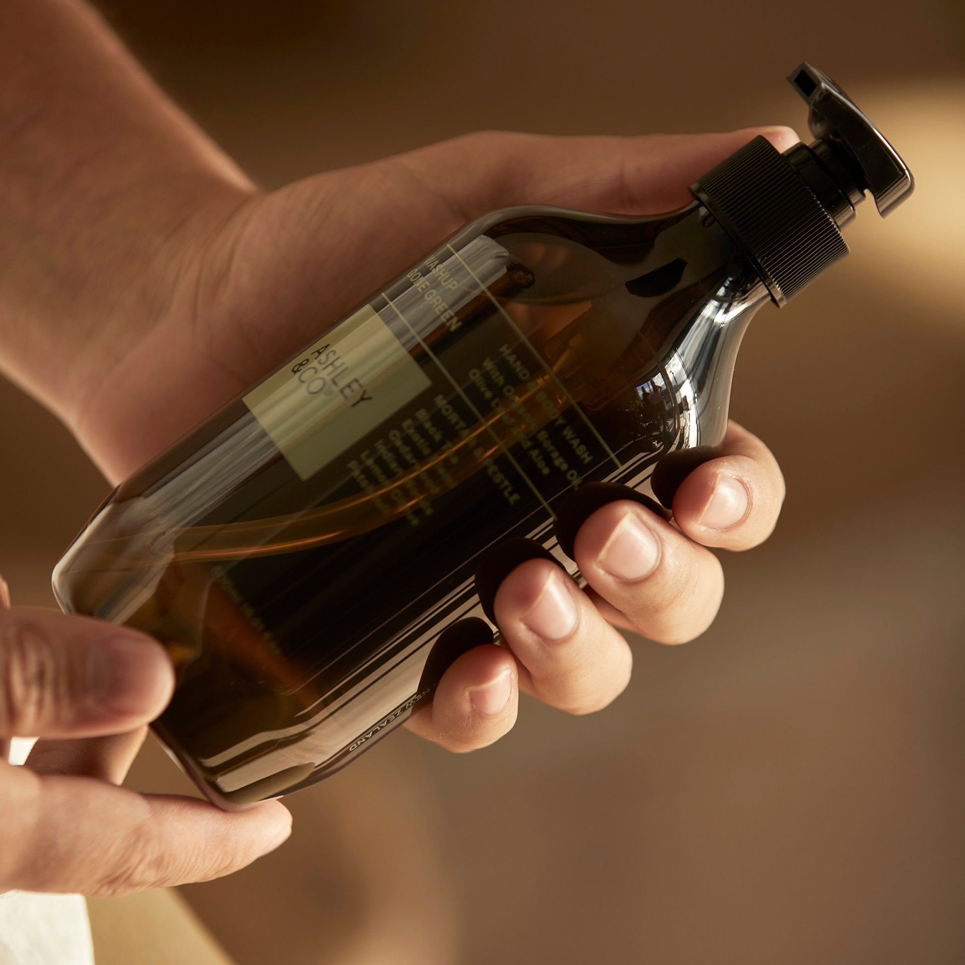 Close up shot of Ashley and Co 'Washup Gone Green' handwash in mortar and pestle fragrance held in a man's hand.