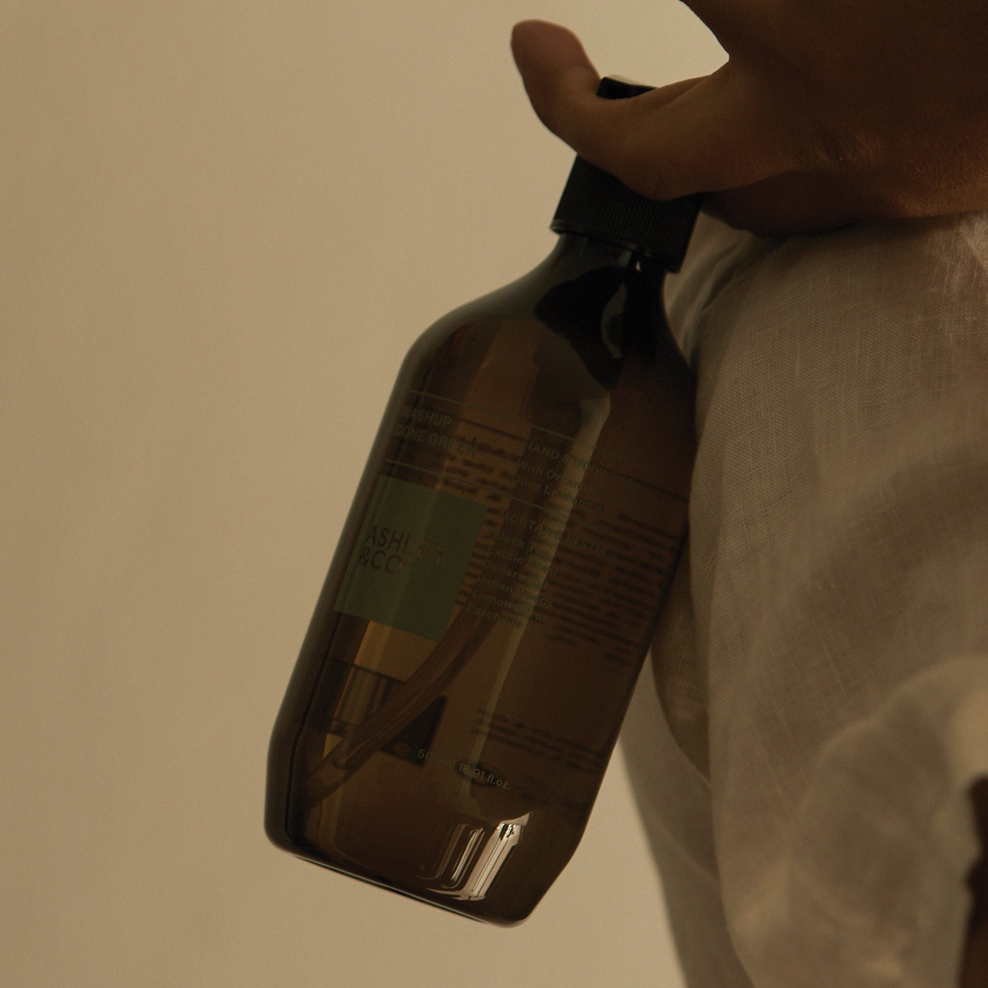 Close up shot of Ashley and Co 'Washup Gone Green' handwash in mortar and pestle fragrance held in a man's hand.