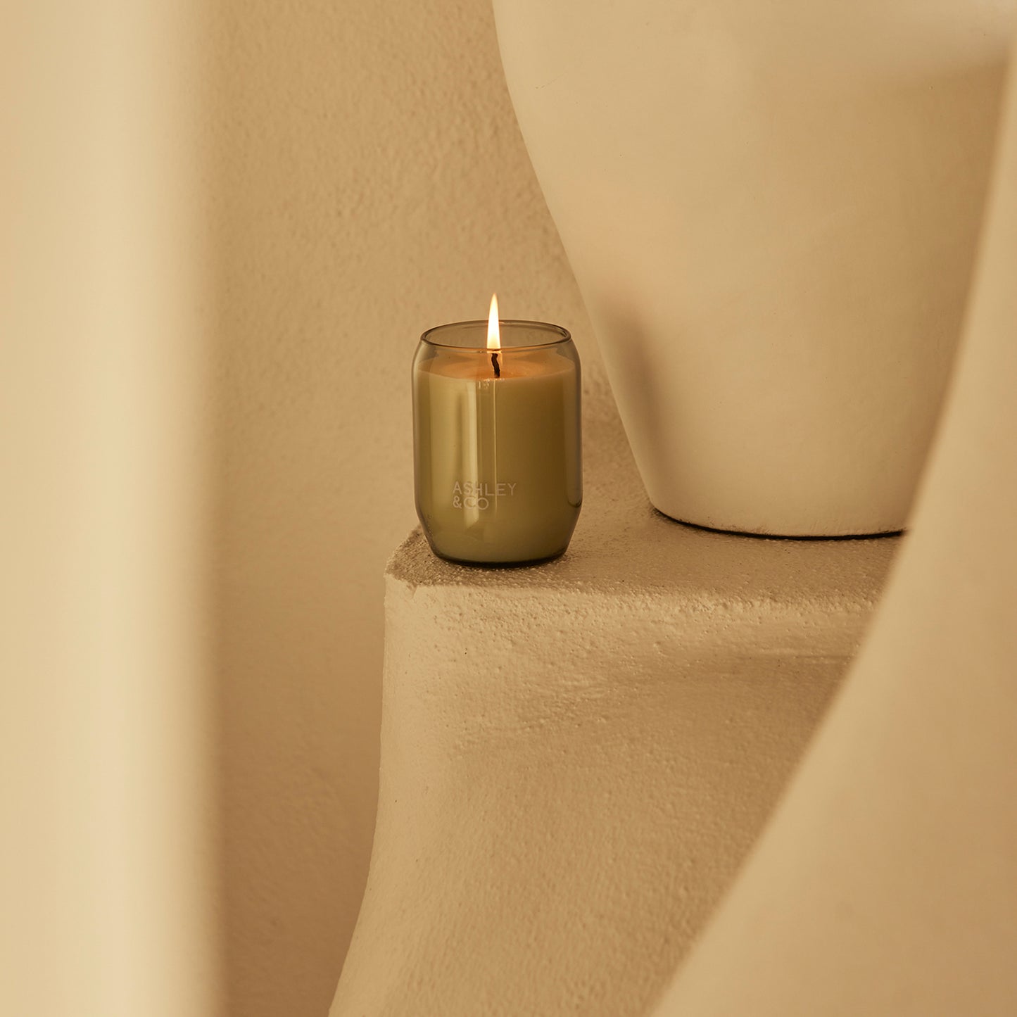 Ashley and Co 'Waxed Perfume' scented candle in parakeets and pearls fragrance placed on a counter.