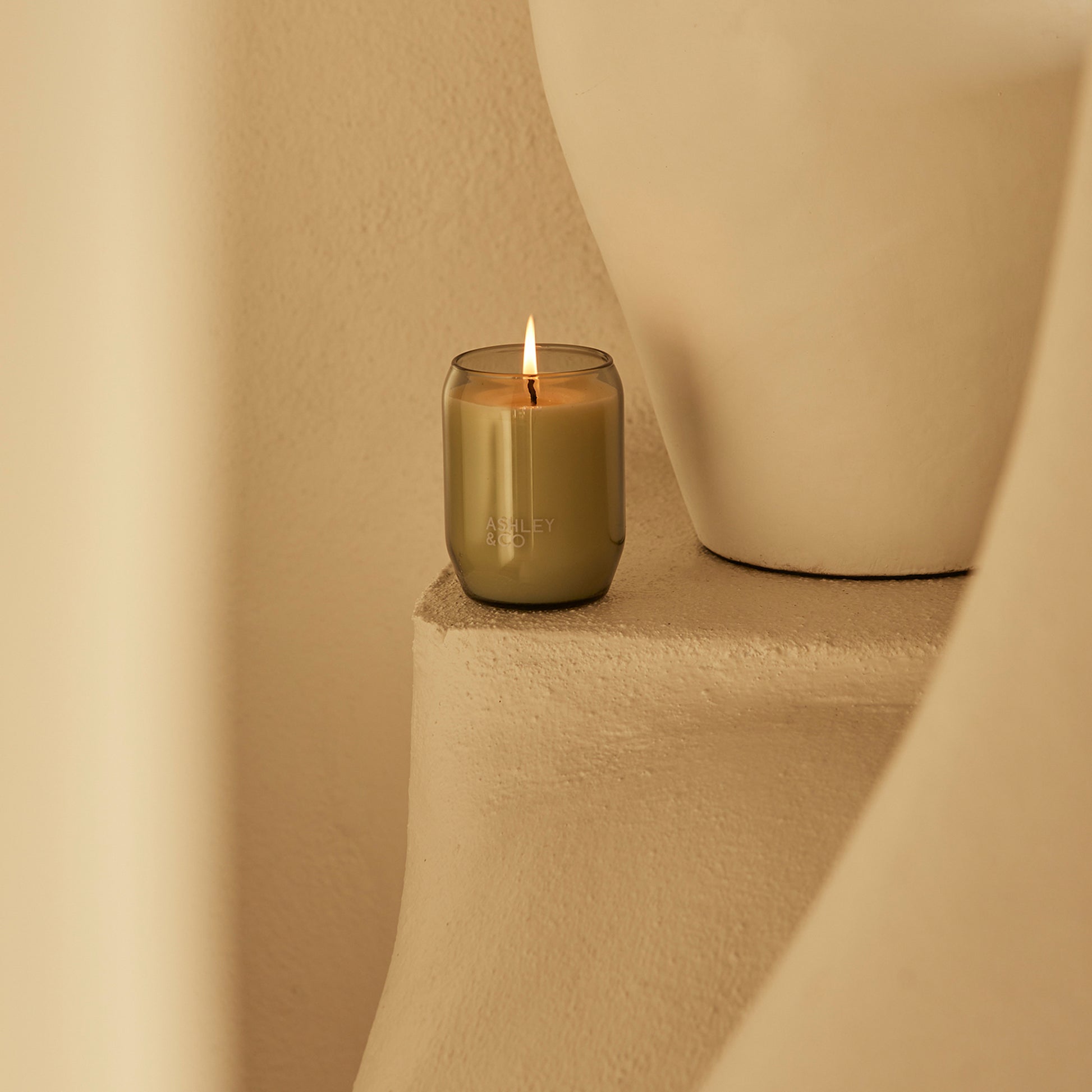 Ashley and Co 'Waxed Perfume' scented candle in parakeets and pearls fragrance placed on a counter.