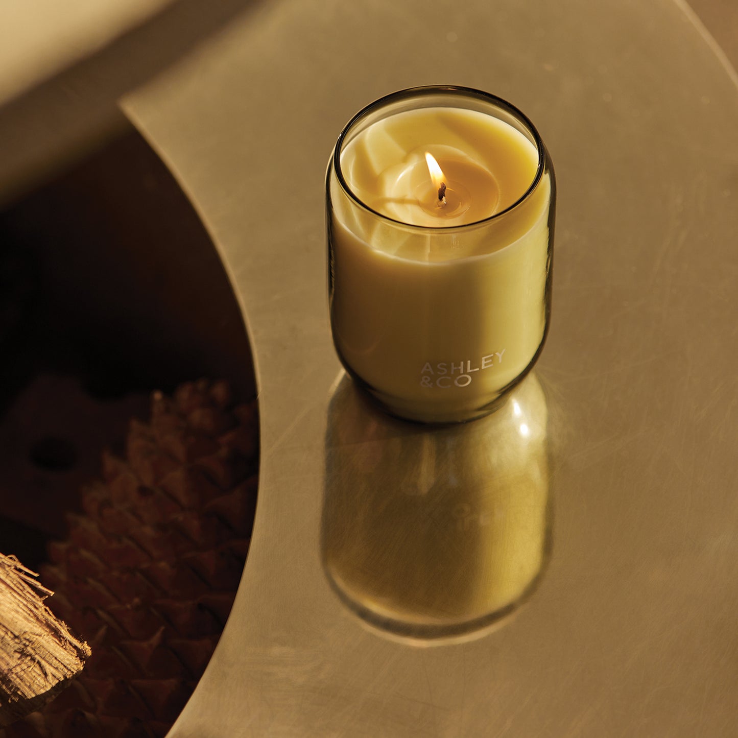Ashley and Co 'Waxed Perfume' scented candle in parakeets and pearls fragrance placed on a mirrored table.