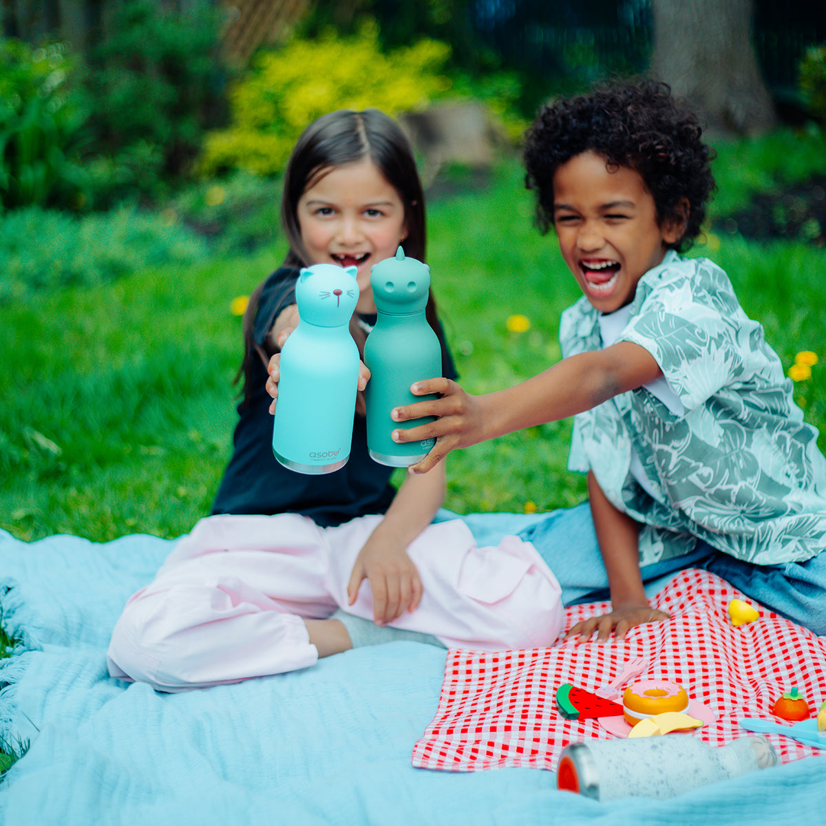 Image showing 2 children cheersing their Cat and Dino Bestie Bottles by Asobu