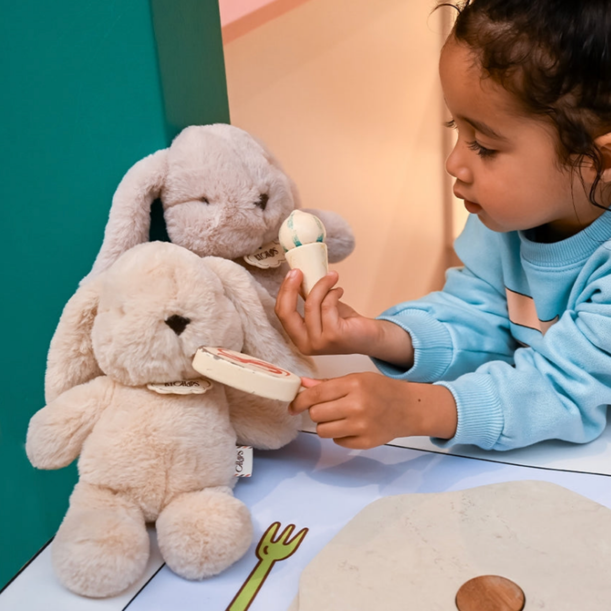 Small girl holding assorted Bon Ton Toys with Bubbles Bunny Ballet pink plush toy and having a tea party lifestyle shot