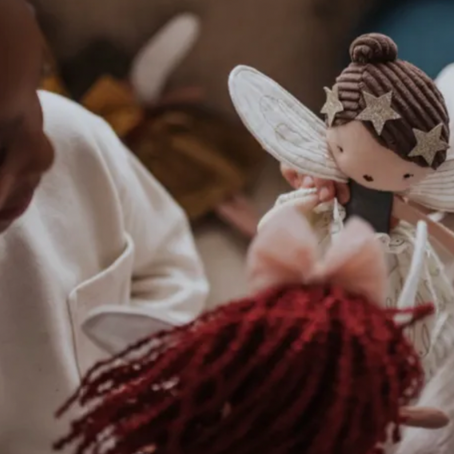 Two young girls playing with assorted Bon Ton Fairies in room