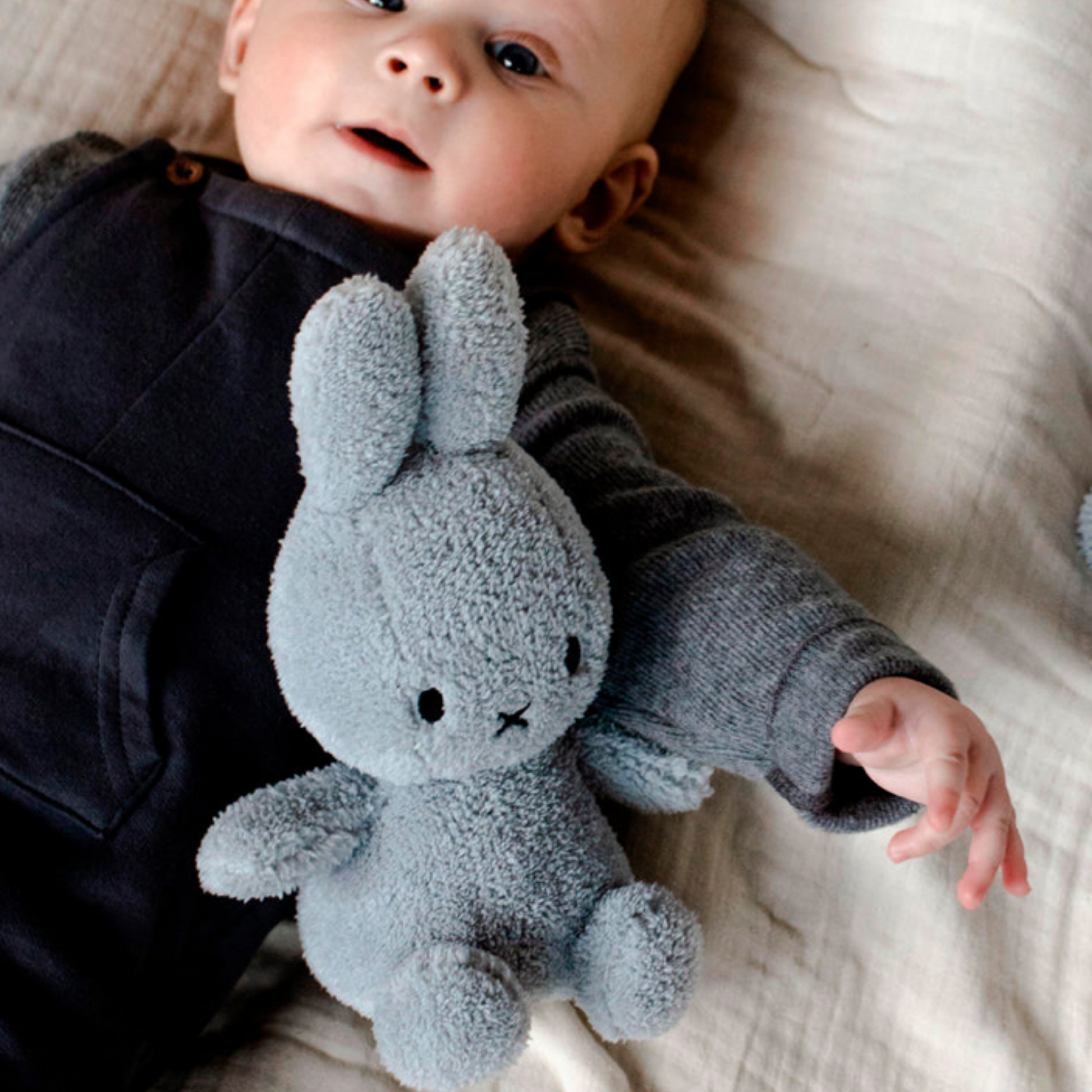 baby in crib cuddling light grey 23cm Bon Ton Toys Miffy plush toy lifestyle shot