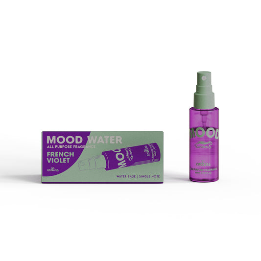 A travel sized bottle of french violet scented mood water by collins, placed next to its box.
