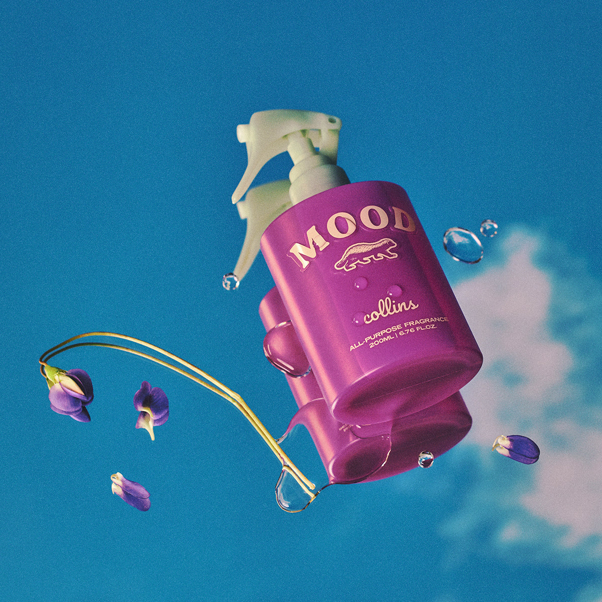 Collins French Violet 200ml water based Mood Water spray bottle laying on blue background with purple flowers
