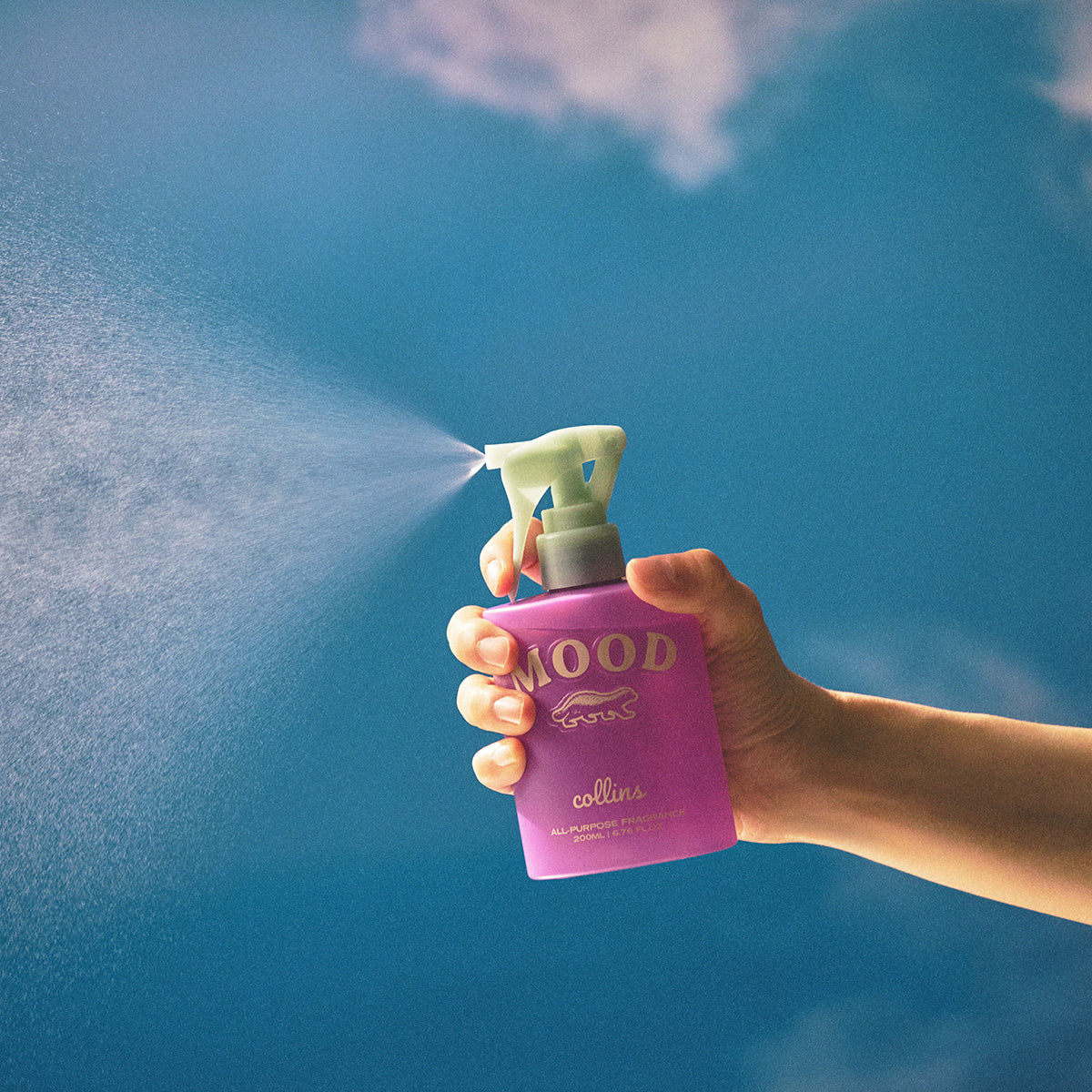 Collins French Violet 200ml water based Mood Water being sprayed with a blue background 