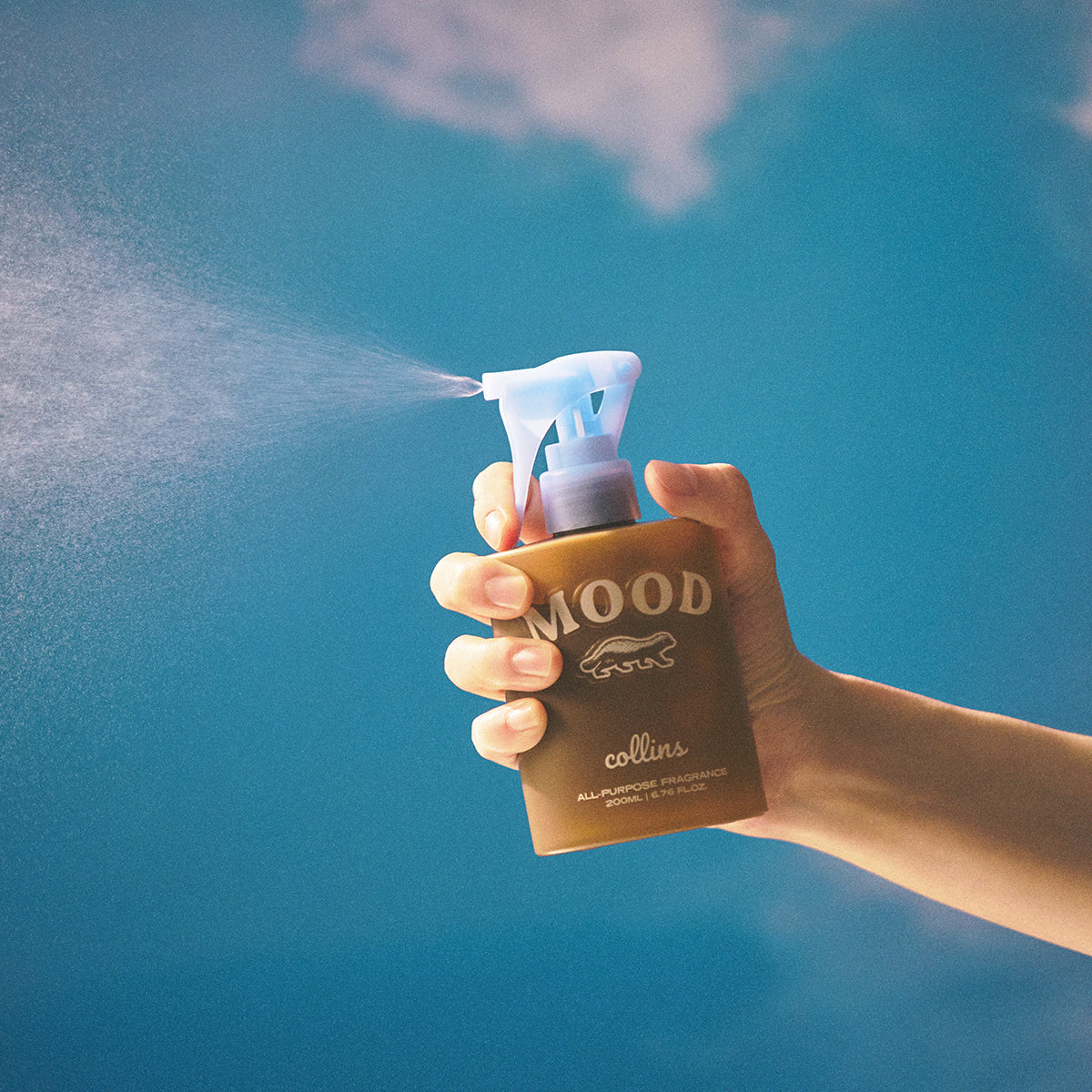 Collins Scottish Juniper 200ml water based Mood Water being sprayed with a blue background 