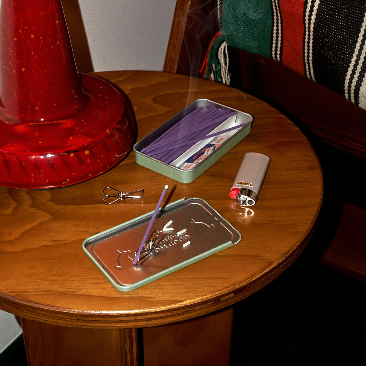 Collins 'Do Not Disturb' natural incense sticks being burn't on coffee table with lighter
