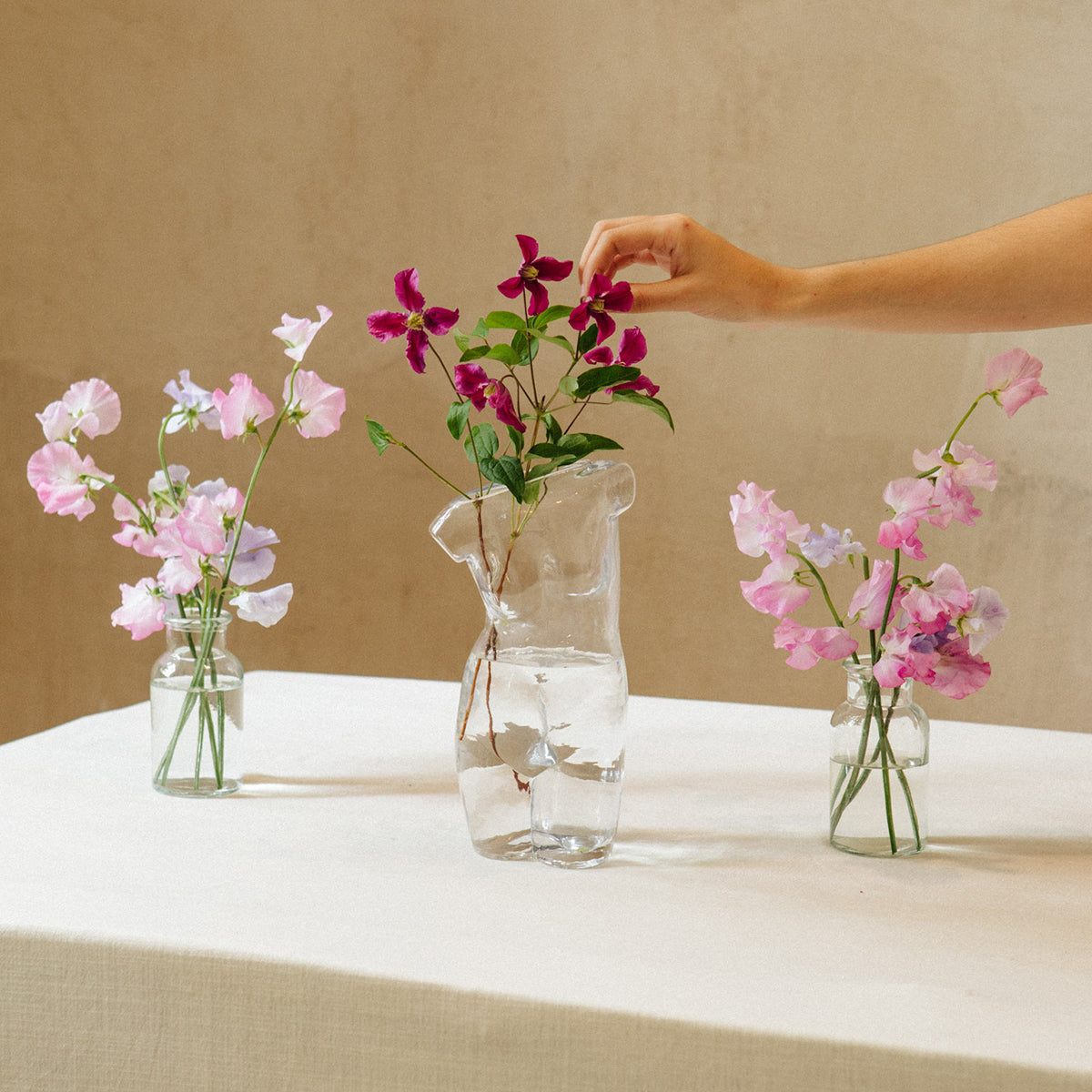 Doiy glass body vase on table with pink flowers