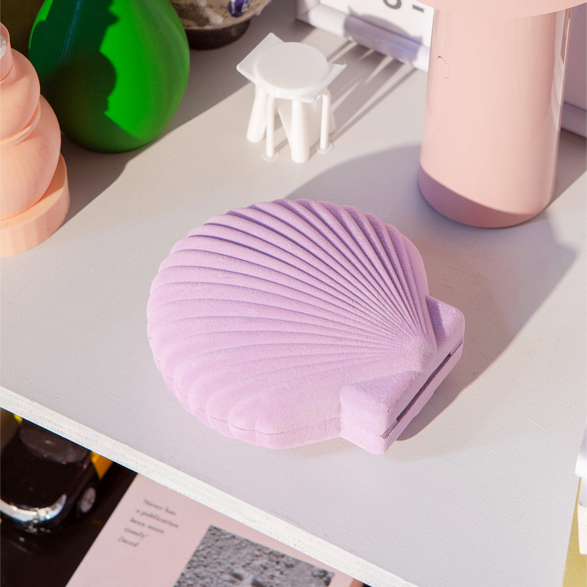 Closed DOIY lilac velvet venus jewelry box on white table next to blush lamp and green vase