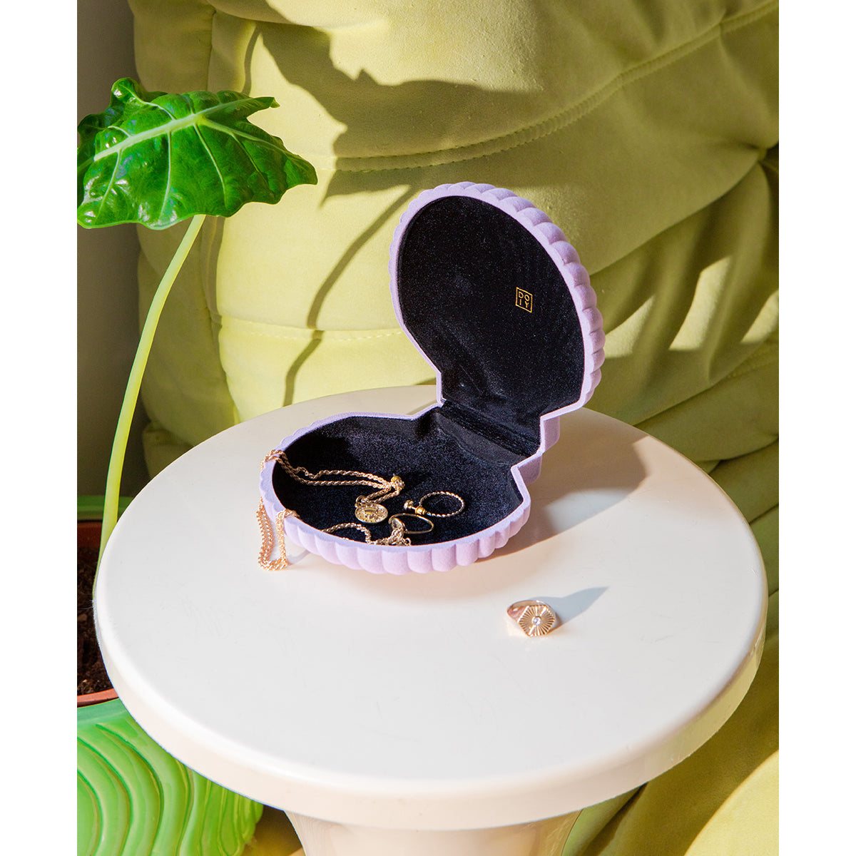 Open DOIY lilac velvet venus jewelry box filled with jewels on white round side table 