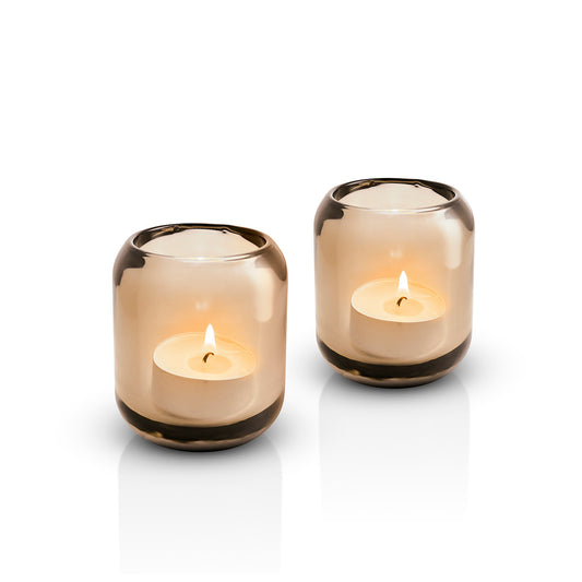 Pair of Eva Solo glass Acorn tealight holders in Amber, with lit candles inside 