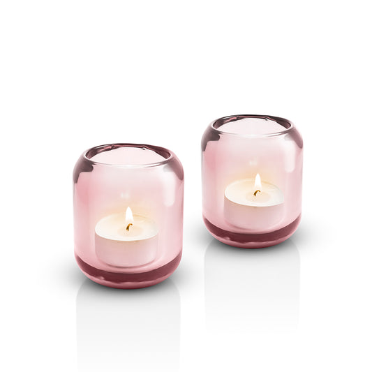 Pair of Eva Solo glass Acorn tealight holders in Rose pink, with lit candles inside 