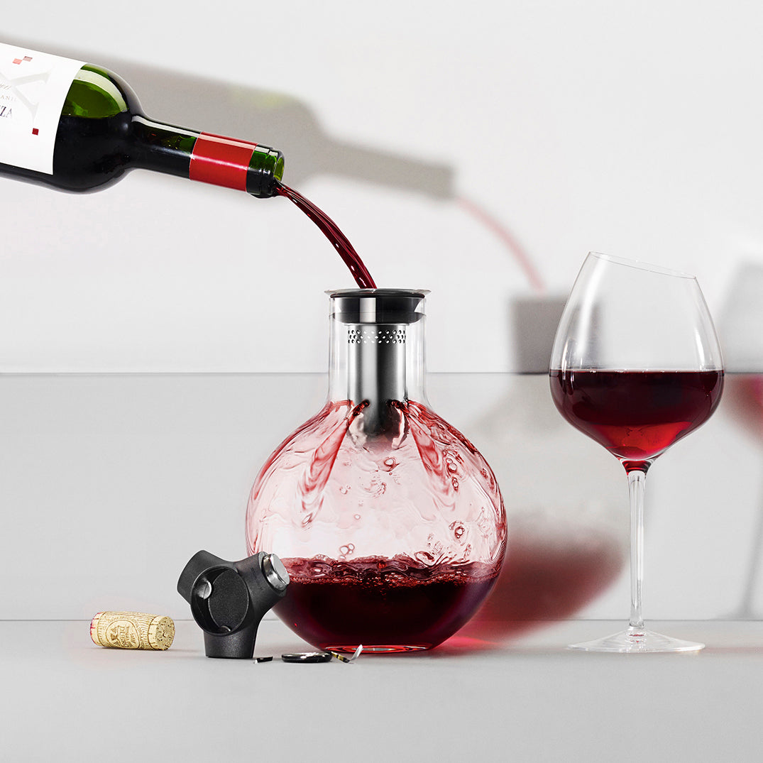 Red wine being poured into Eva Solo's Decanter Caraf with a cork and full wine glass sitting alongside