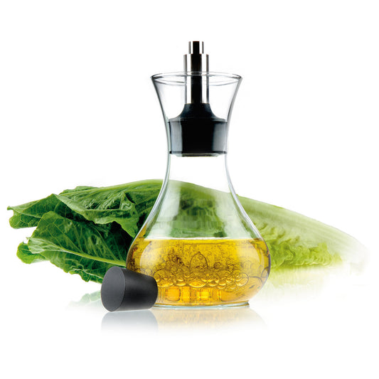 Eva Solo dressing shaker - clear glass bottle, filled with oil and placed beside Chinese cabbage; transparent food-safe container for mixing and storing salad dressings, oils, and liquid seasonings.