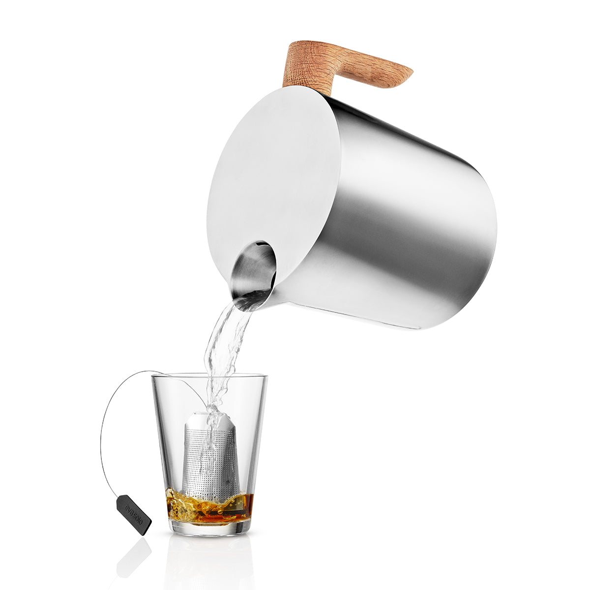 Shown pouring hot water for a tea using Eva Solo Nordic Kitchen induction kettle - black and silver stovetop kettle with oak handle, stainless steel and aluminum body, 1L capacity for fast boiling on induction.
