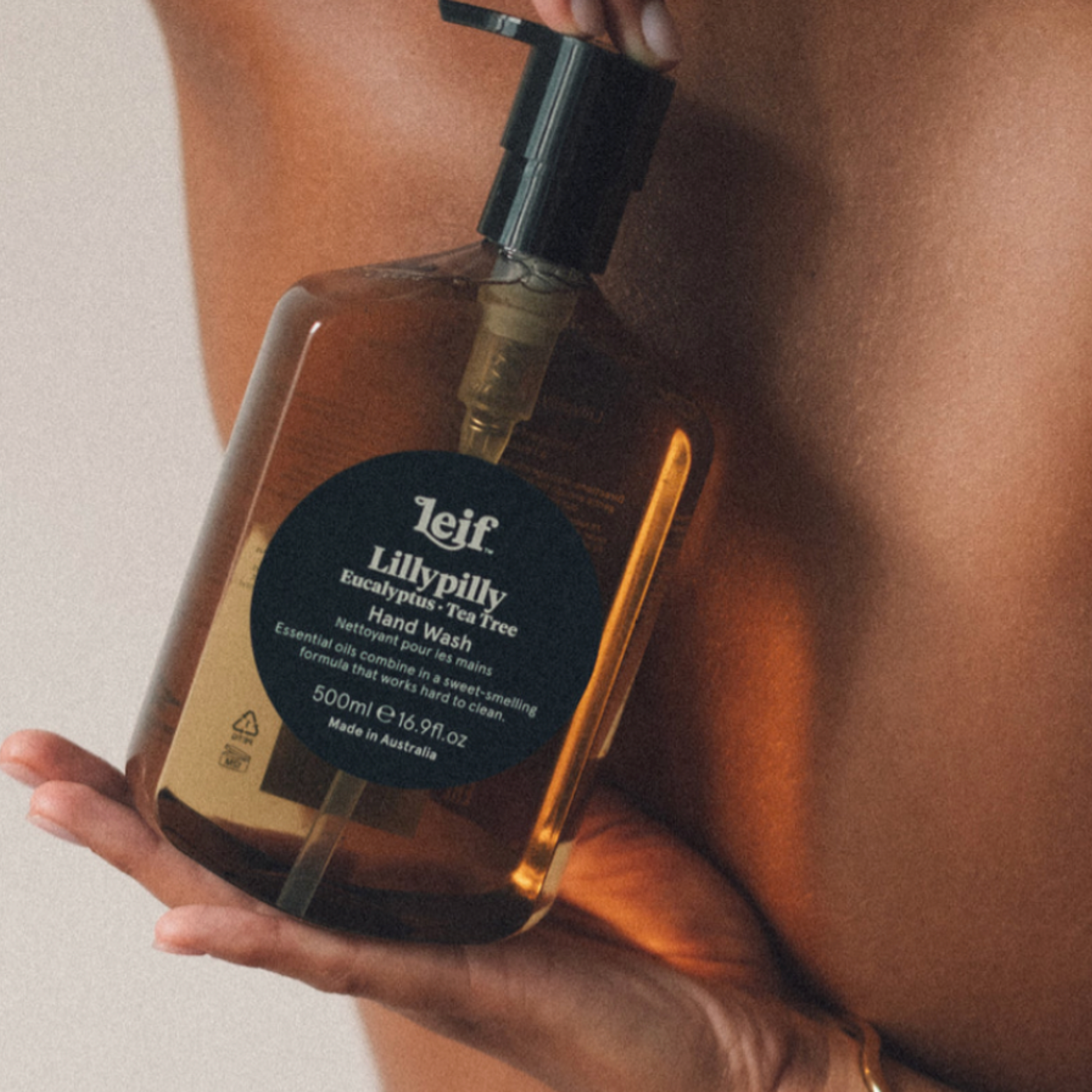 Man holding Leif hand wash 500ml Lillypilly behind his back 
