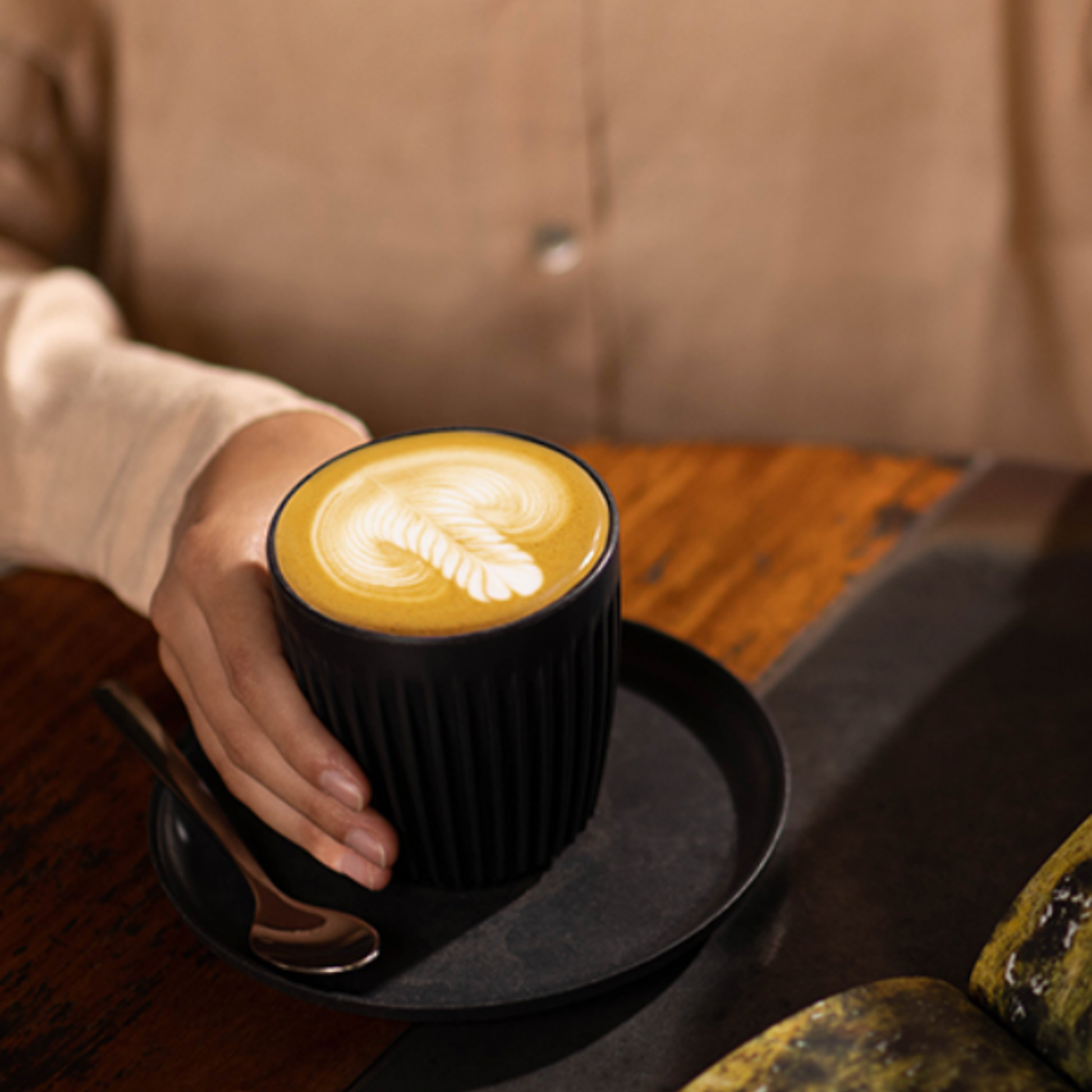 HuskeeCup 8oz with Lid Charcoal in cafe with woman holding coffee cup at table 