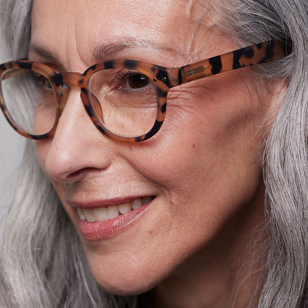Izipizi shape c light tortoise reading glasses close up of front right hand side on white background