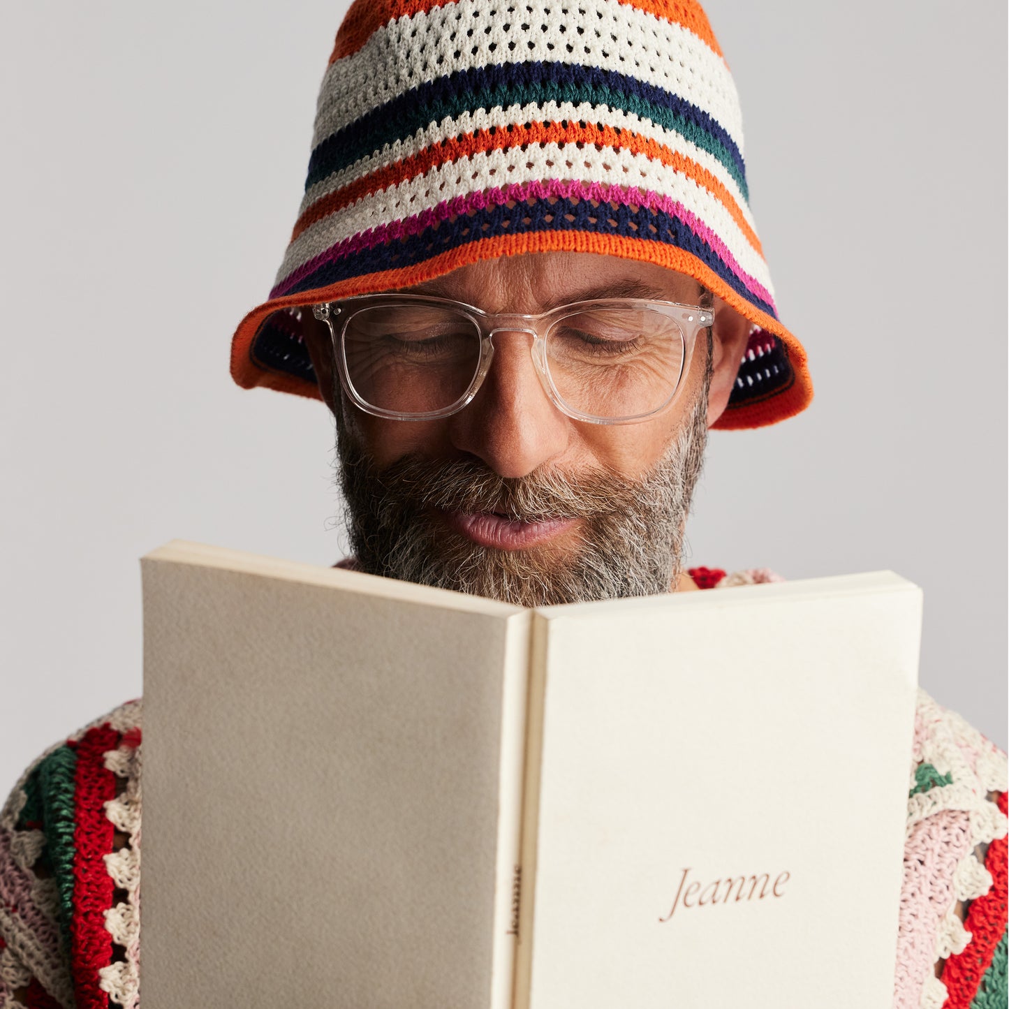 Front view of an old male model wearing IZIPIZI Reading Collection E Crystal reading glasses with lightweight rubber-textured frame and flexible spring hinges - unisex trapezium-shaped eyewear for clear, comfortable reading in a modern transparent design.