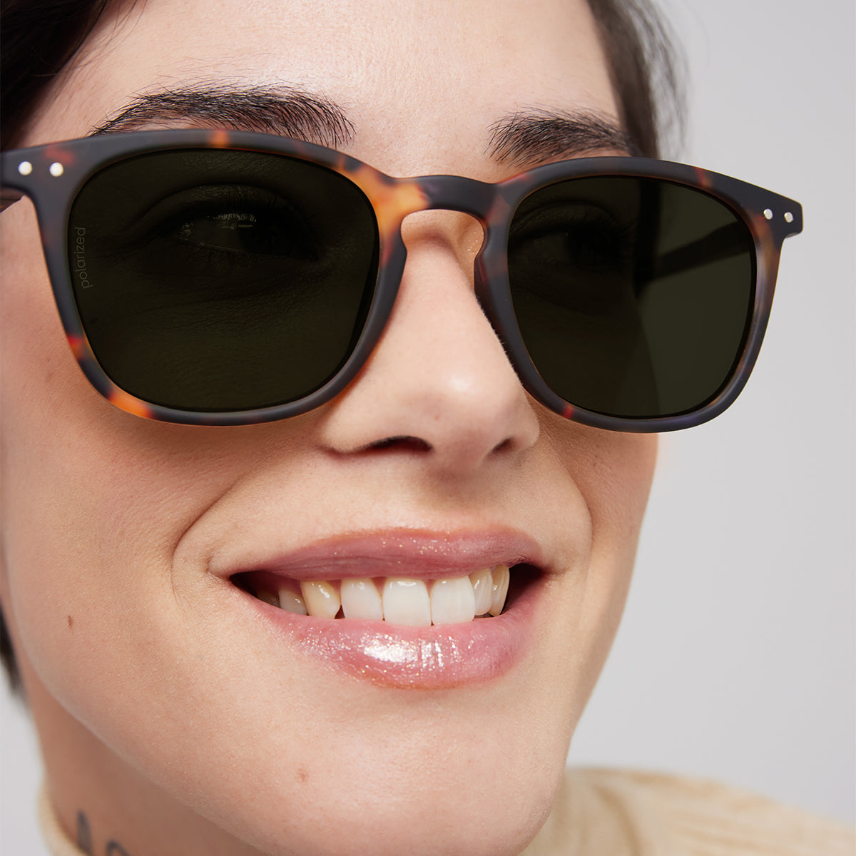 Close up of woman wearing Izipizi shape e tortoise sunglasses on an angle
