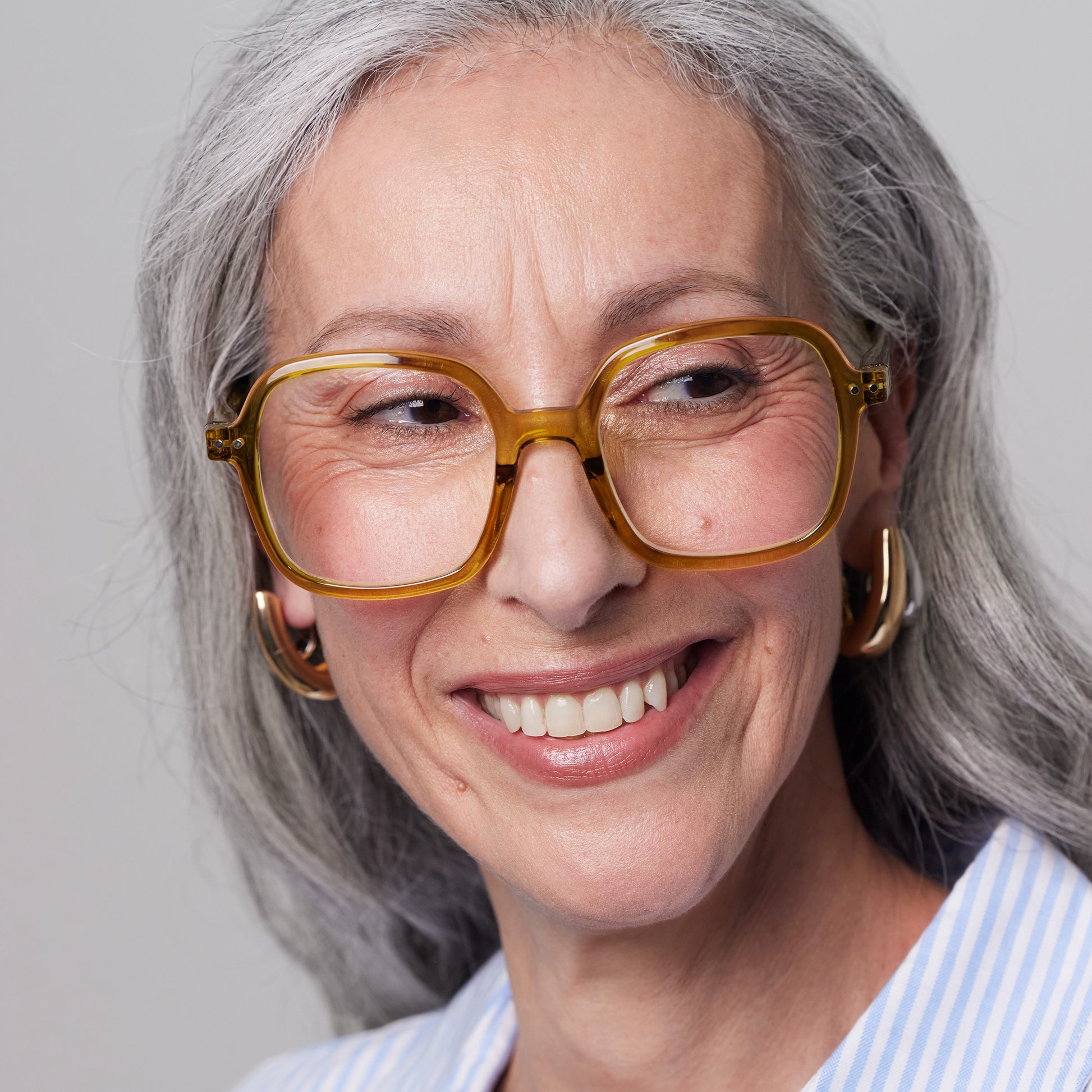 Front view of old woman model using the IZIPIZI Reading Collection O Golden Green glasses made from eco-friendly bio-sourced polyamide with flexible spring hinges and a soft-touch texture - lightweight unisex reading eyewear featuring oversized square frames.
