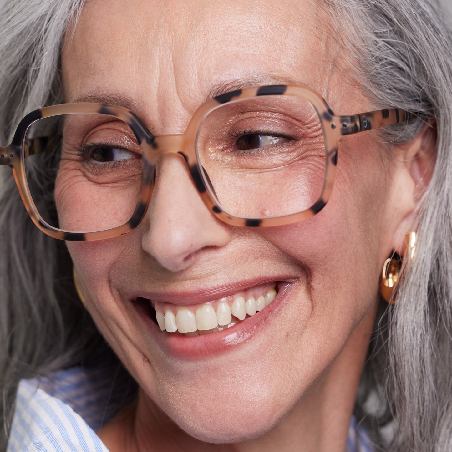 Front view of old woman wearing the IZIPIZI Reading Collection O Light Tortoise glasses made from bio-sourced organic polyamide, featuring flexible spring hinges and a soft-touch finish - lightweight unisex reading eyewear with oversized square frames.