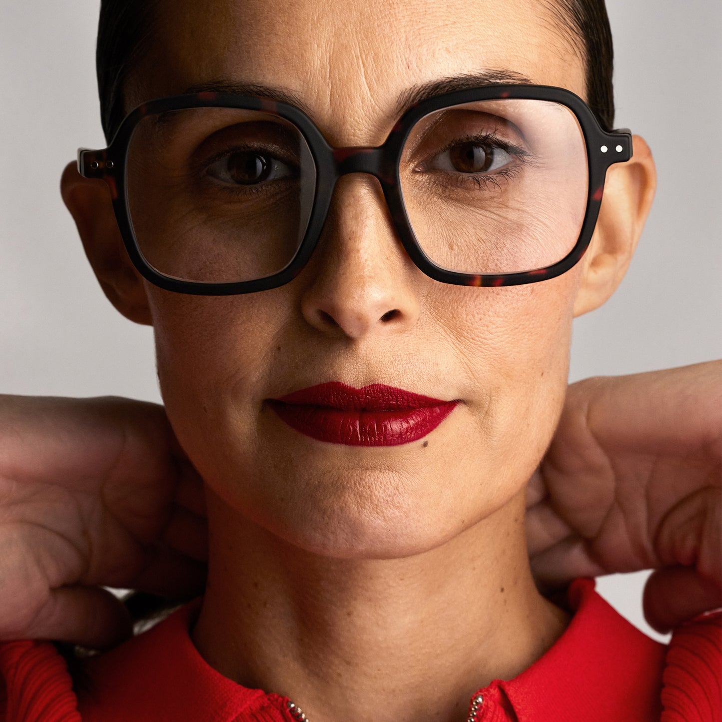Front view of a woman wearing the IZIPIZI Reading Collection O Tortoise glasses with bio-sourced frame, soft-touch finish, flexible spring hinges, and oversized retro square design - lightweight unisex reading eyewear available in +1 to +3 diopters, includes soft pouch and gift box.