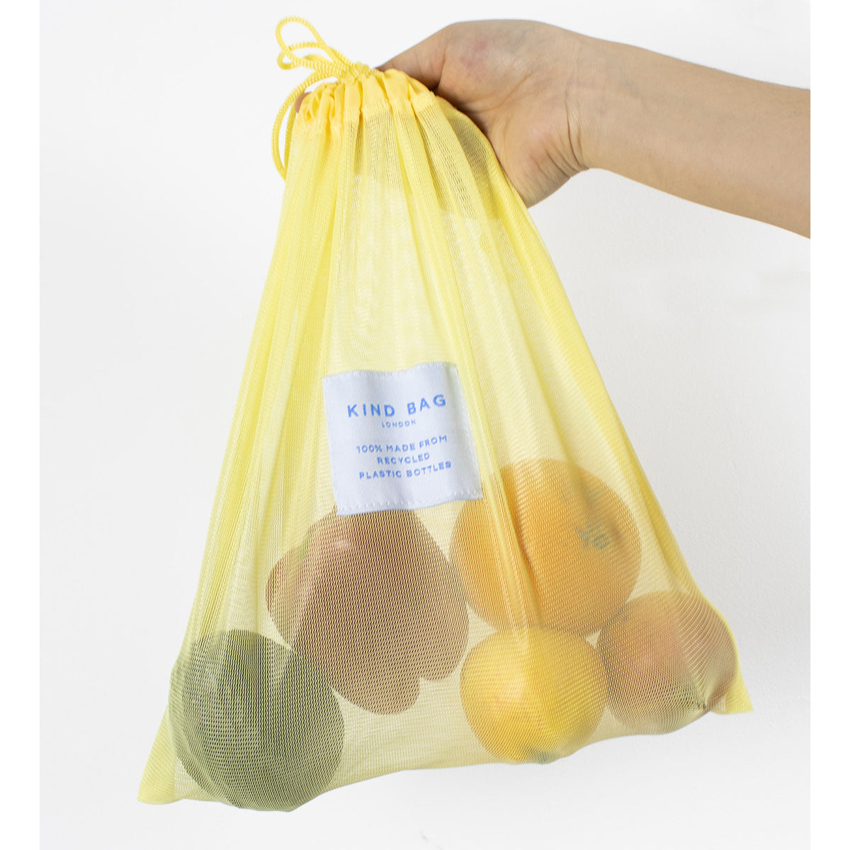 Image showing medium bag from set of 3 Regusable Mesh bags by Kind bag holding fruit and vegetables.