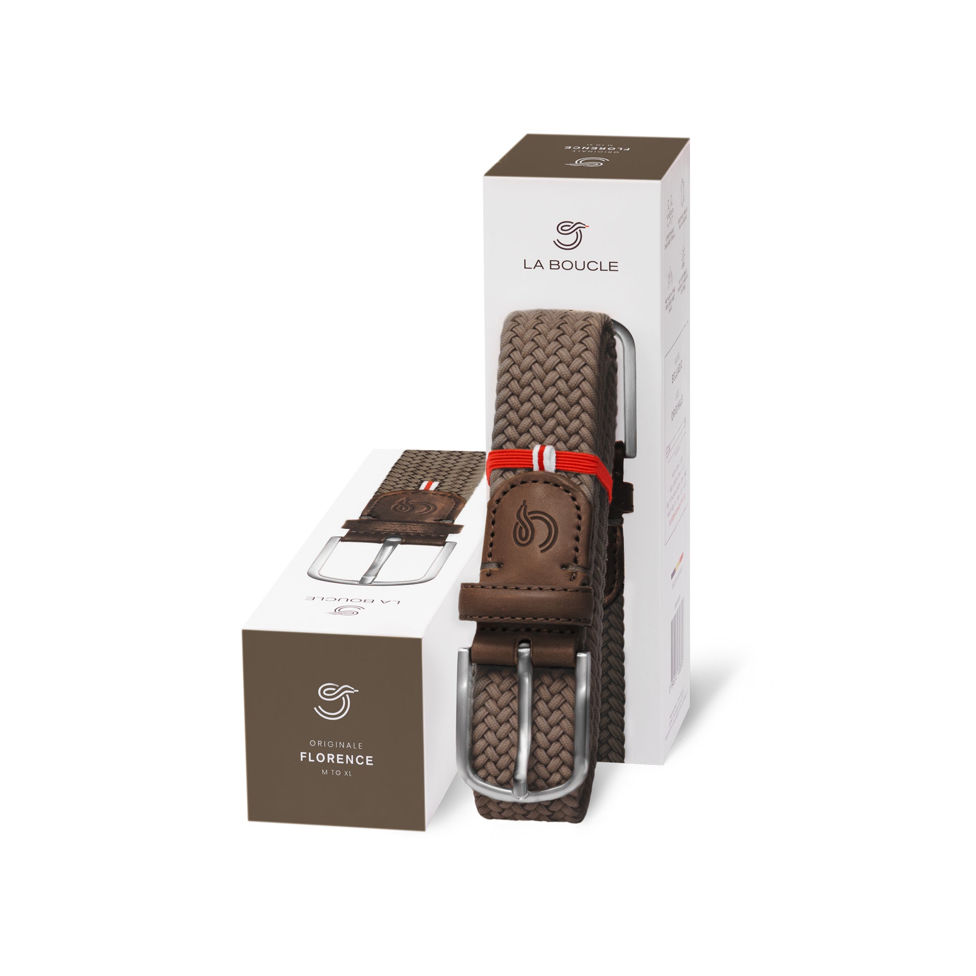 La Boucle mono edinburgh woven belt folded and leaning on a box next to a box on white background