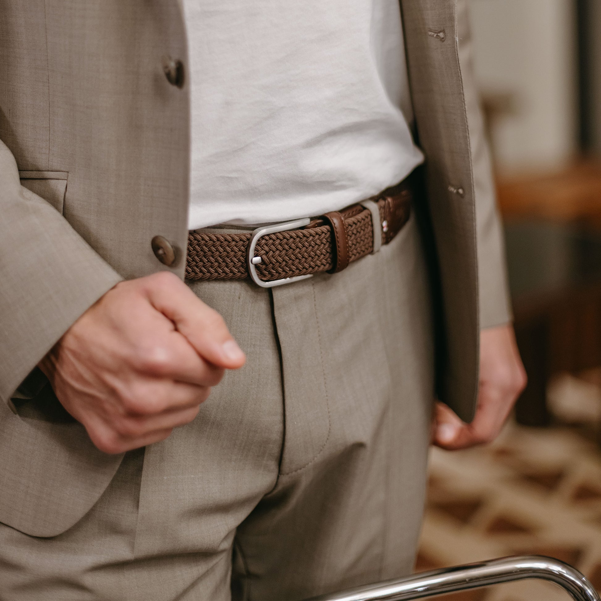 Close up of man wearing La Boucle mono edinburgh woven belt around pale blue pants and beige white tshirt 