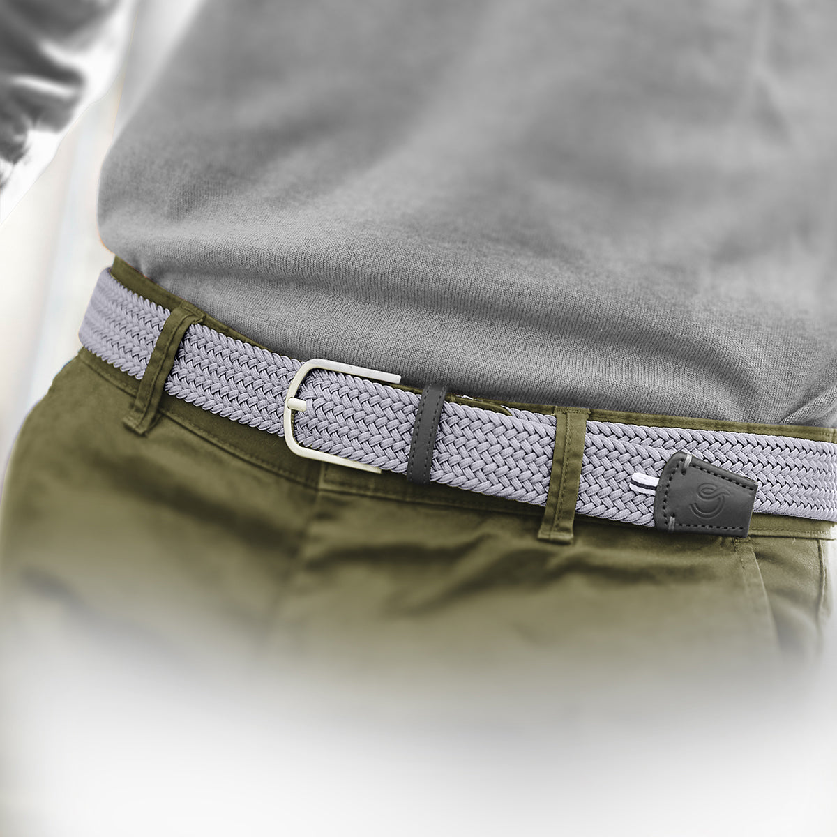 Close up of man wearing La Boucle mono edinburgh woven belt around pale blue pants and beige white tshirt 
