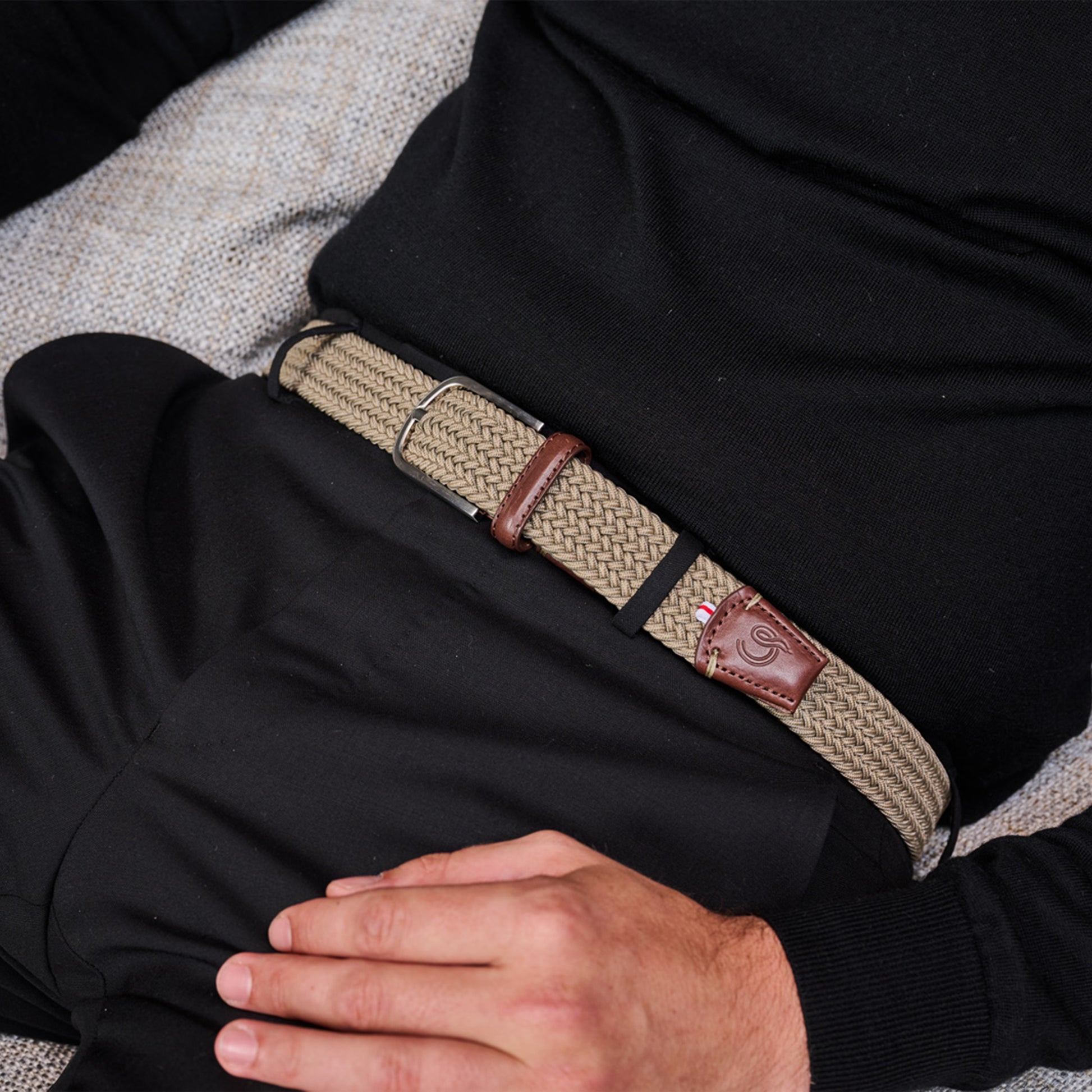 Close up of man wearing La Boucle mono Verbier woven belt around black pants, and black top