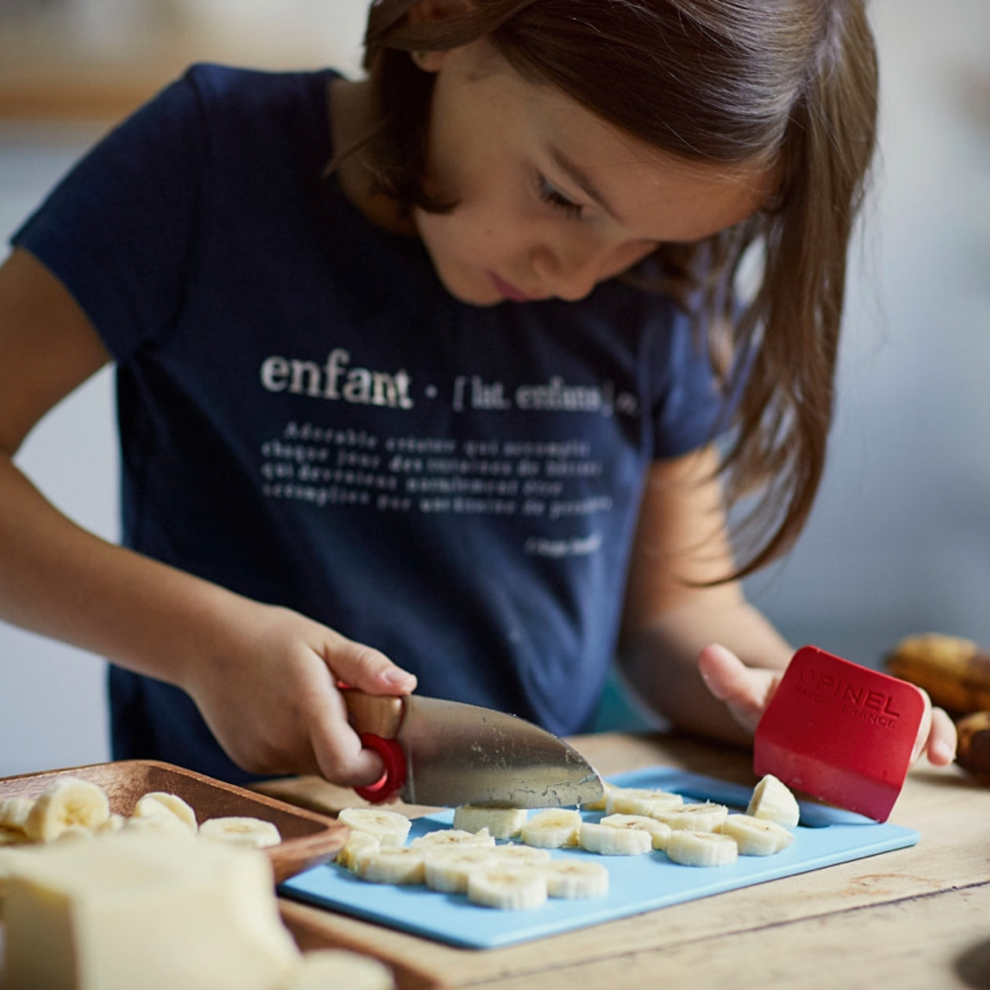Young girl using Opinel Le Petit Chef 3pc Set SS Red with knife and kunckle cover