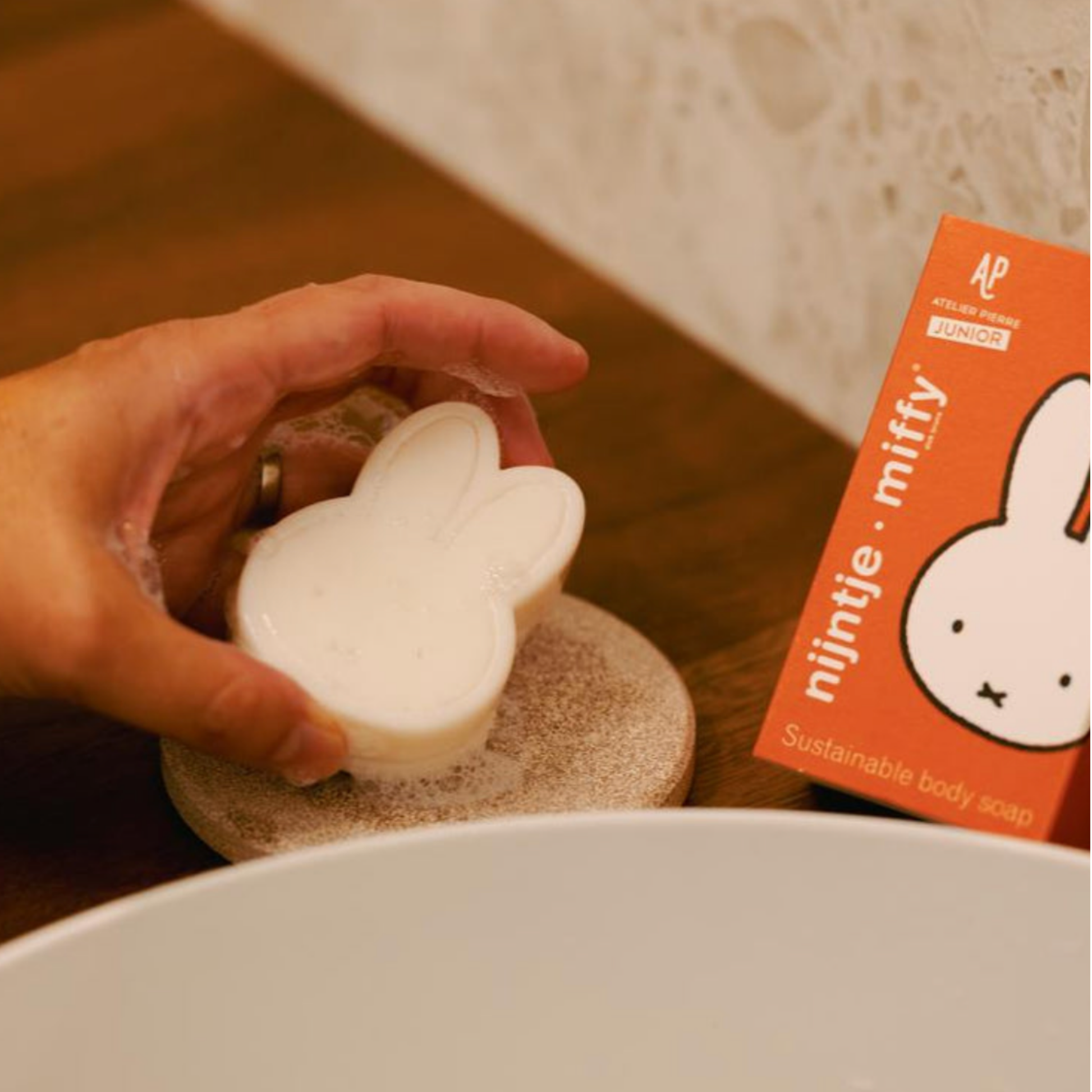 Child washing hands using the Miffy Red Berry Parfum Soap bar at sink with box in top right