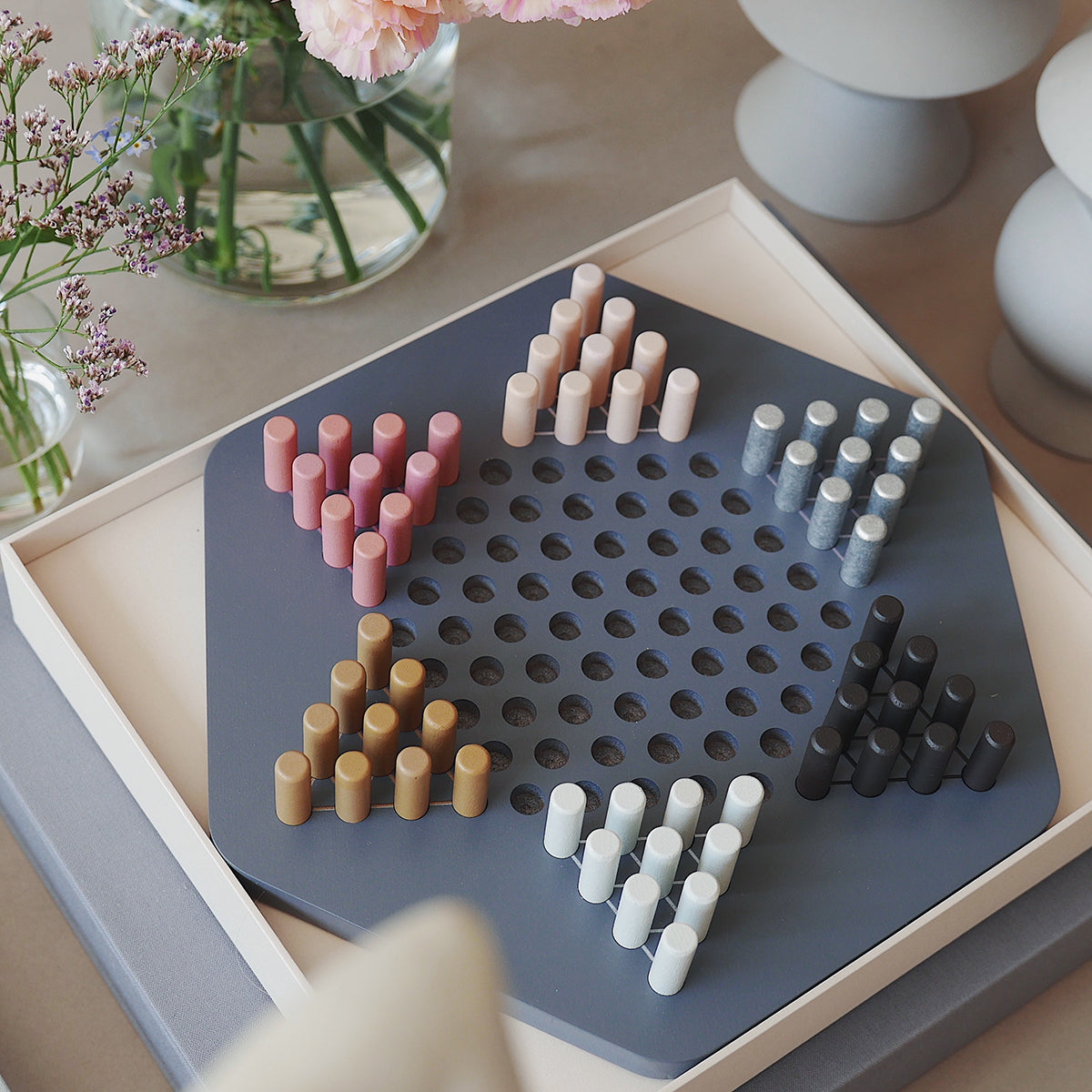 Printworks classic chinese checkers game set up on coffee table next to flowers