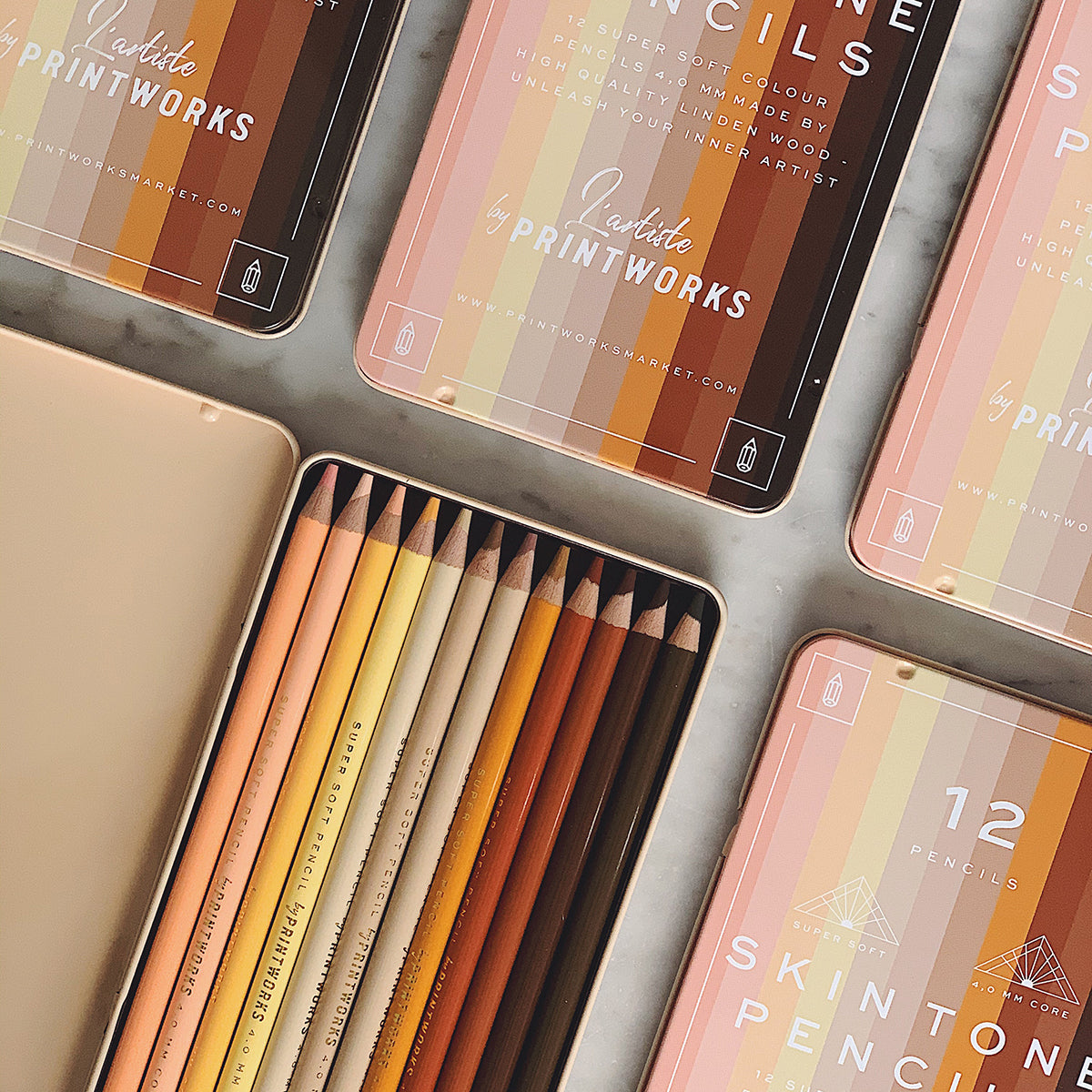 Five boxes of Printworks skin tone pencils set of 12 on an angle on white marble table 
